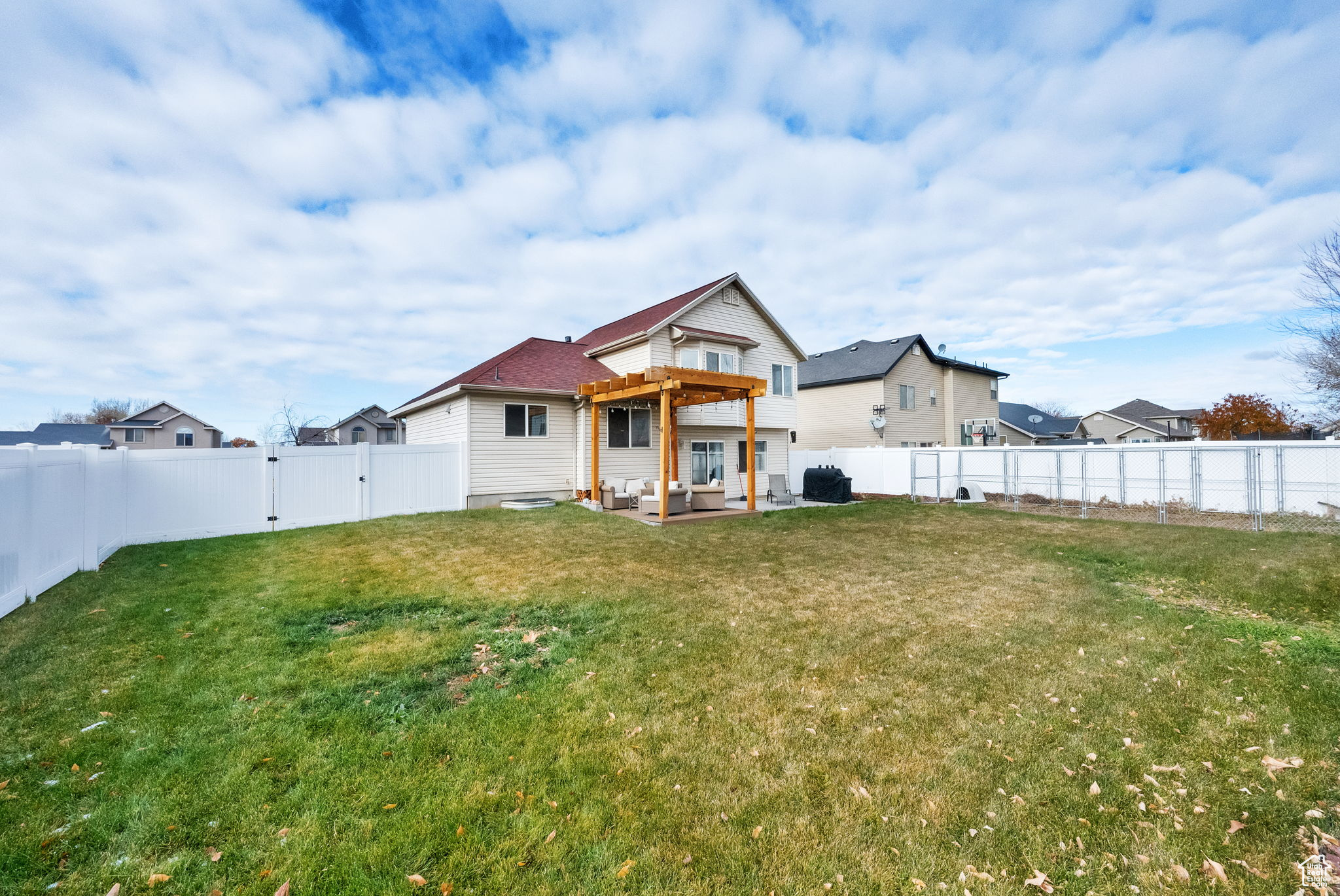 Back of house with outdoor lounge area, a patio area, a pergola, and a yard