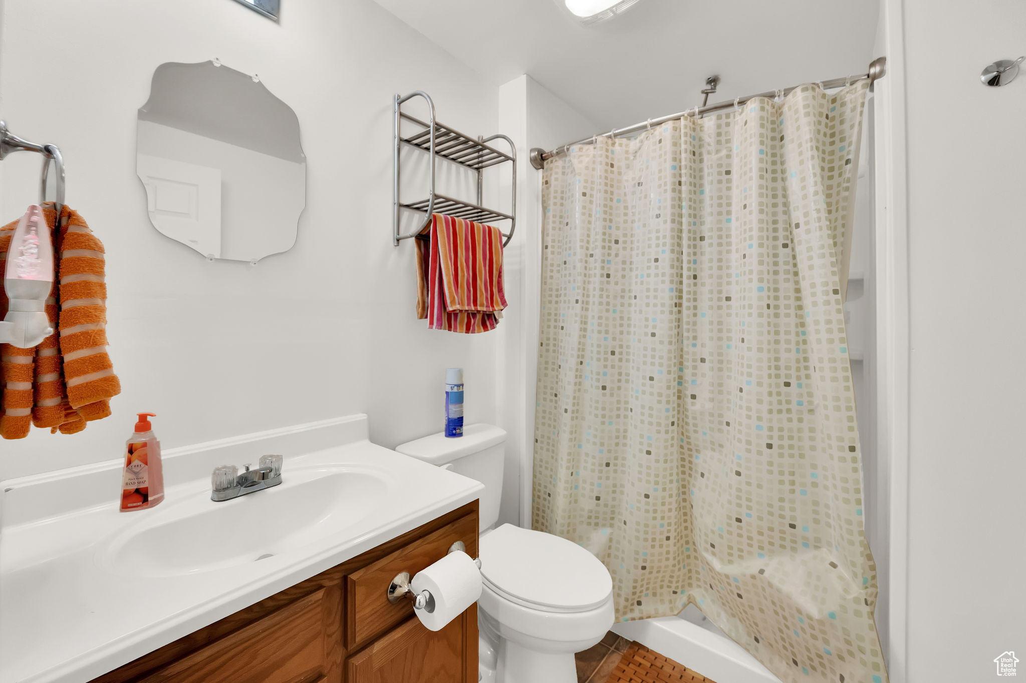 Bathroom with a shower with shower curtain, vanity, and toilet