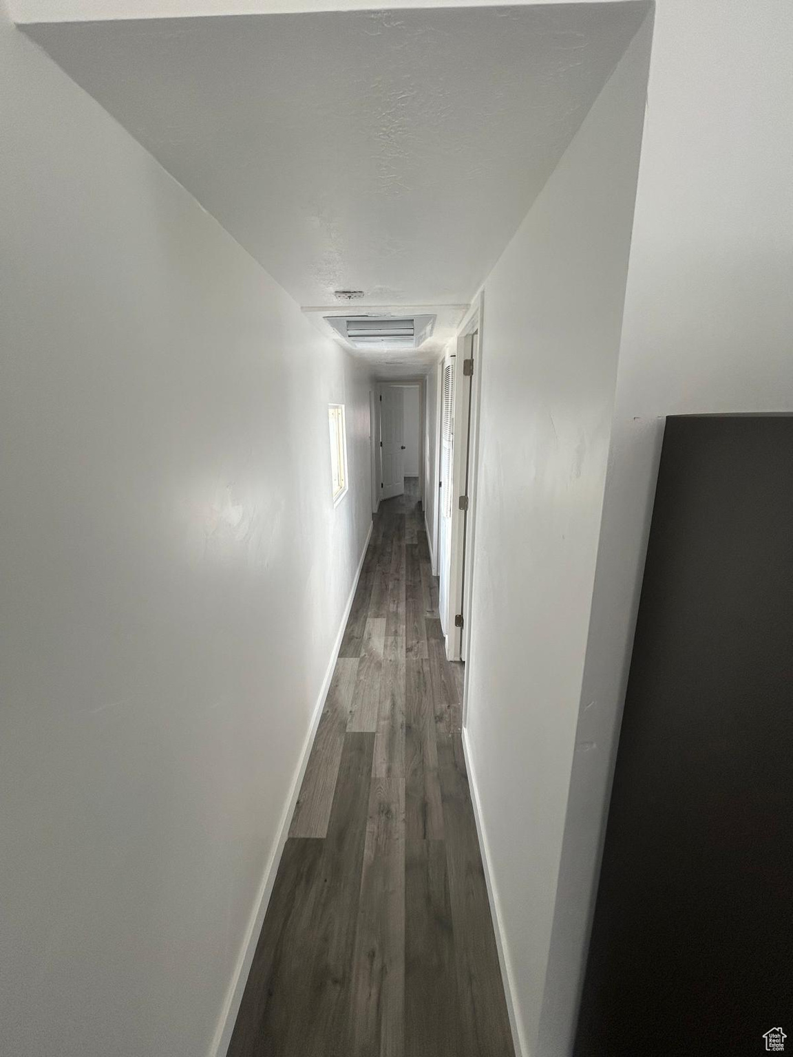 Hallway with dark hardwood / wood-style flooring