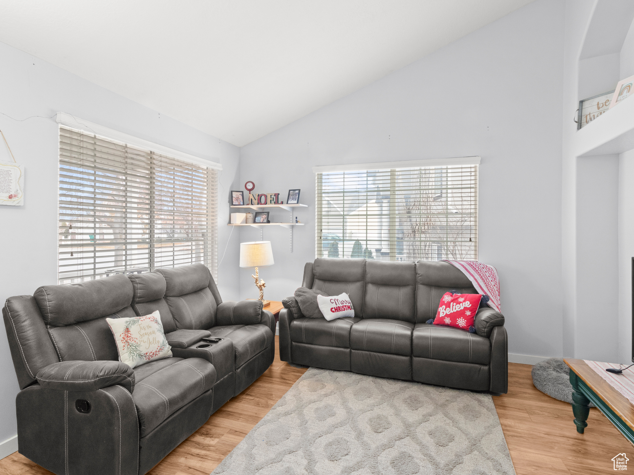 Living room with high vaulted ceiling and light hardwood / wood-style floors