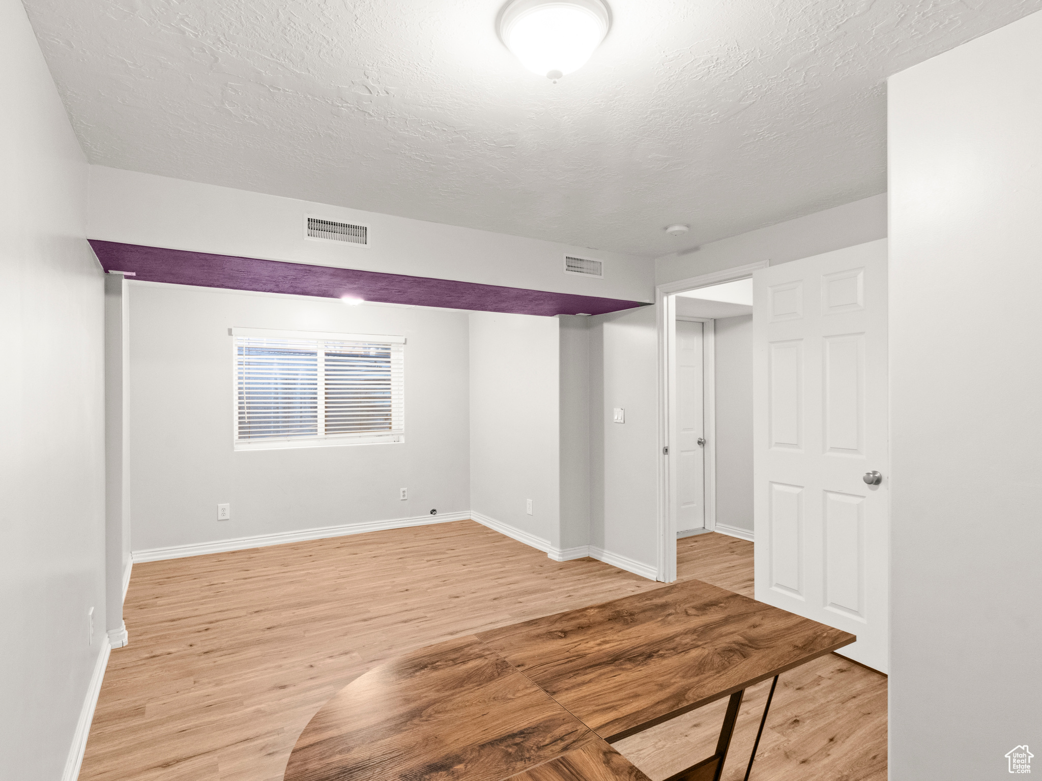 Basement featuring light hardwood / wood-style flooring and a textured ceiling