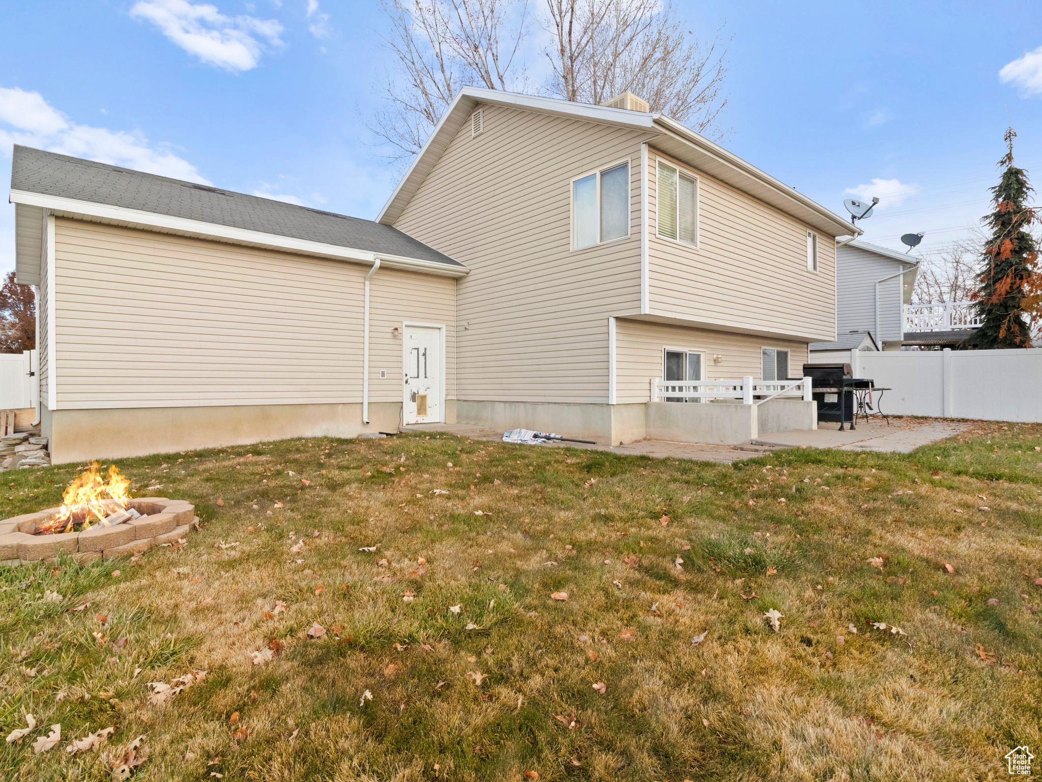 Back of property featuring a patio area, a yard, and an outdoor fire pit