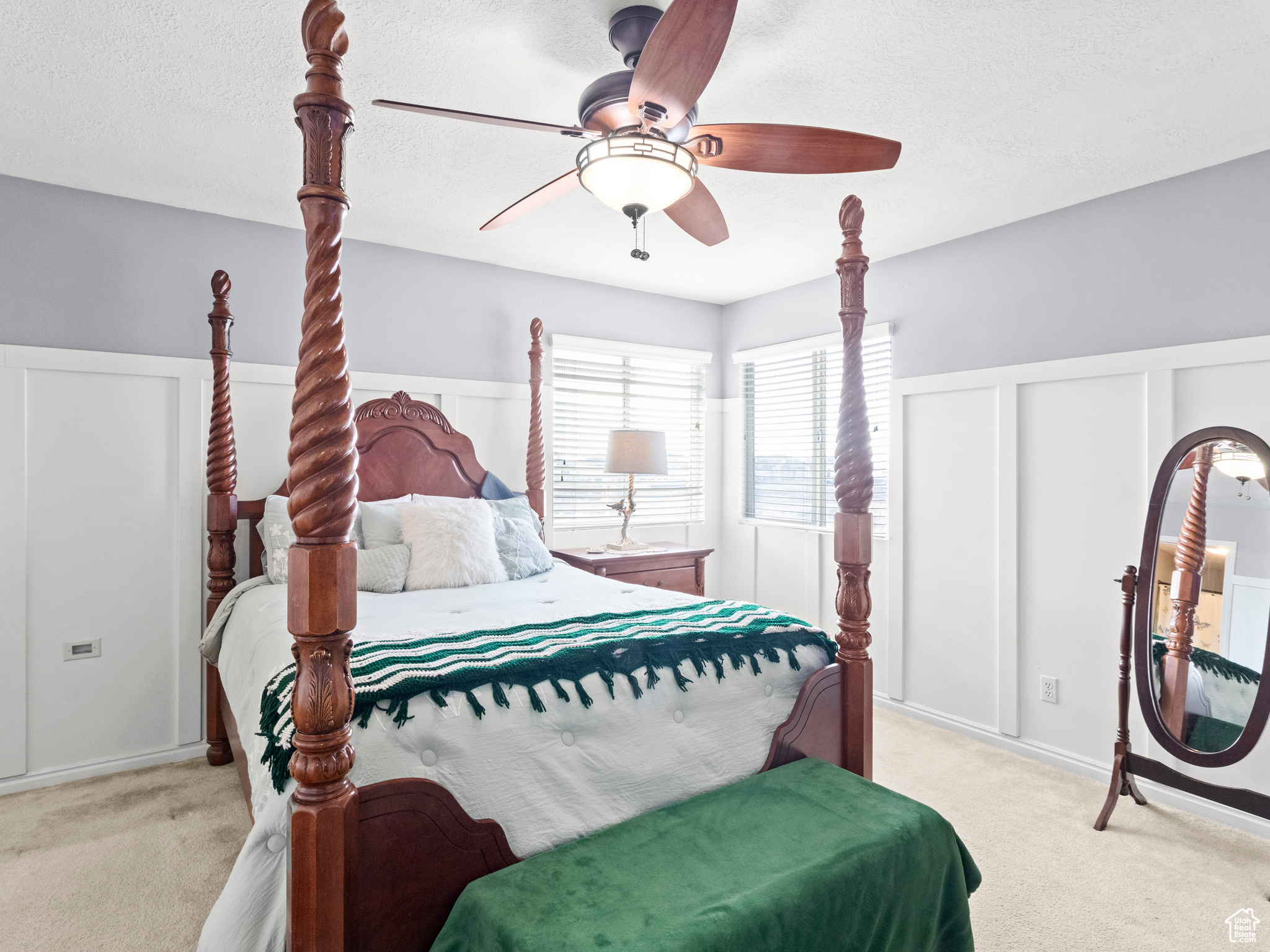 Bedroom with light carpet, a textured ceiling, and ceiling fan