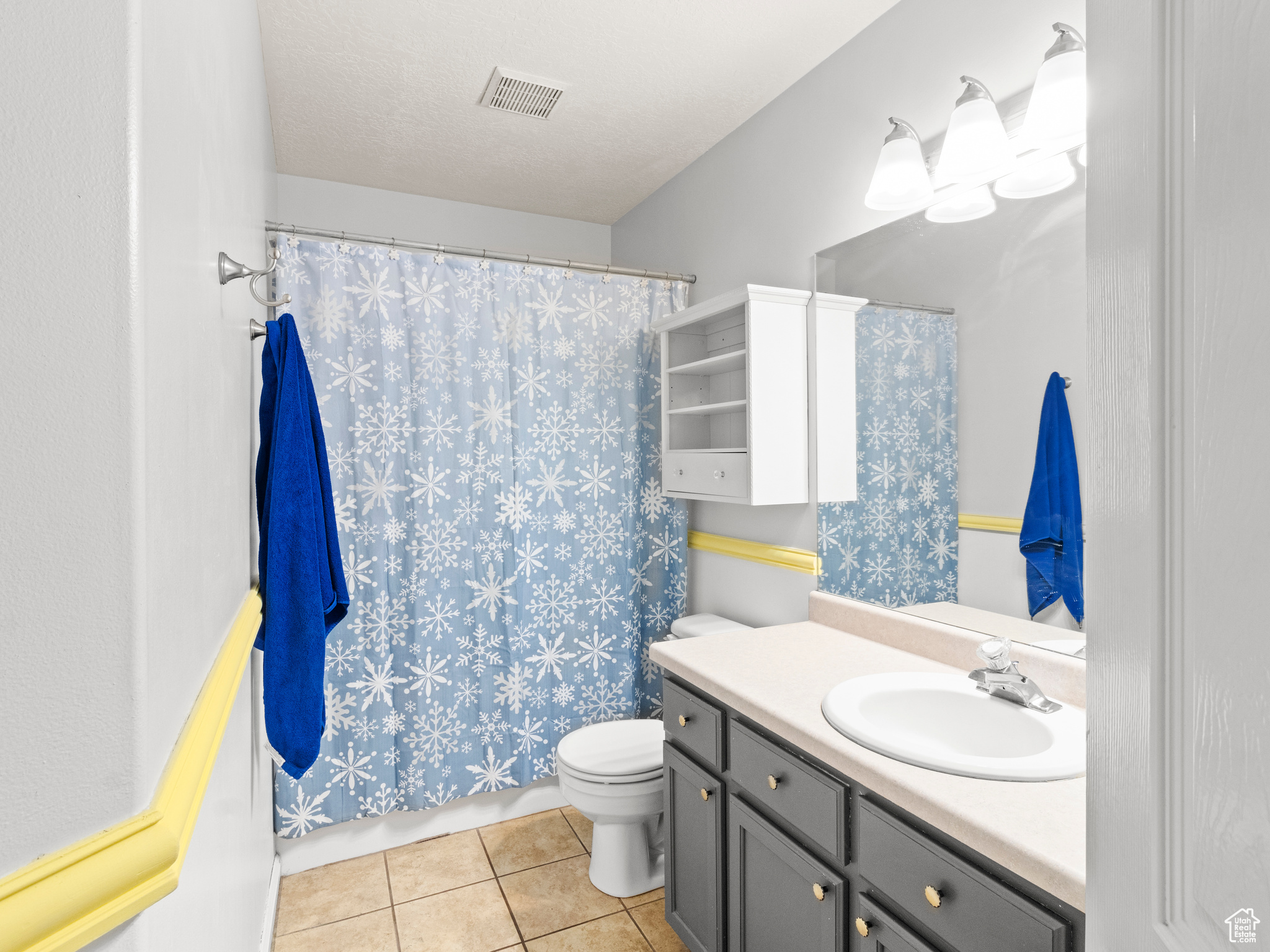 Bathroom with tile patterned floors, vanity, a textured ceiling, and toilet