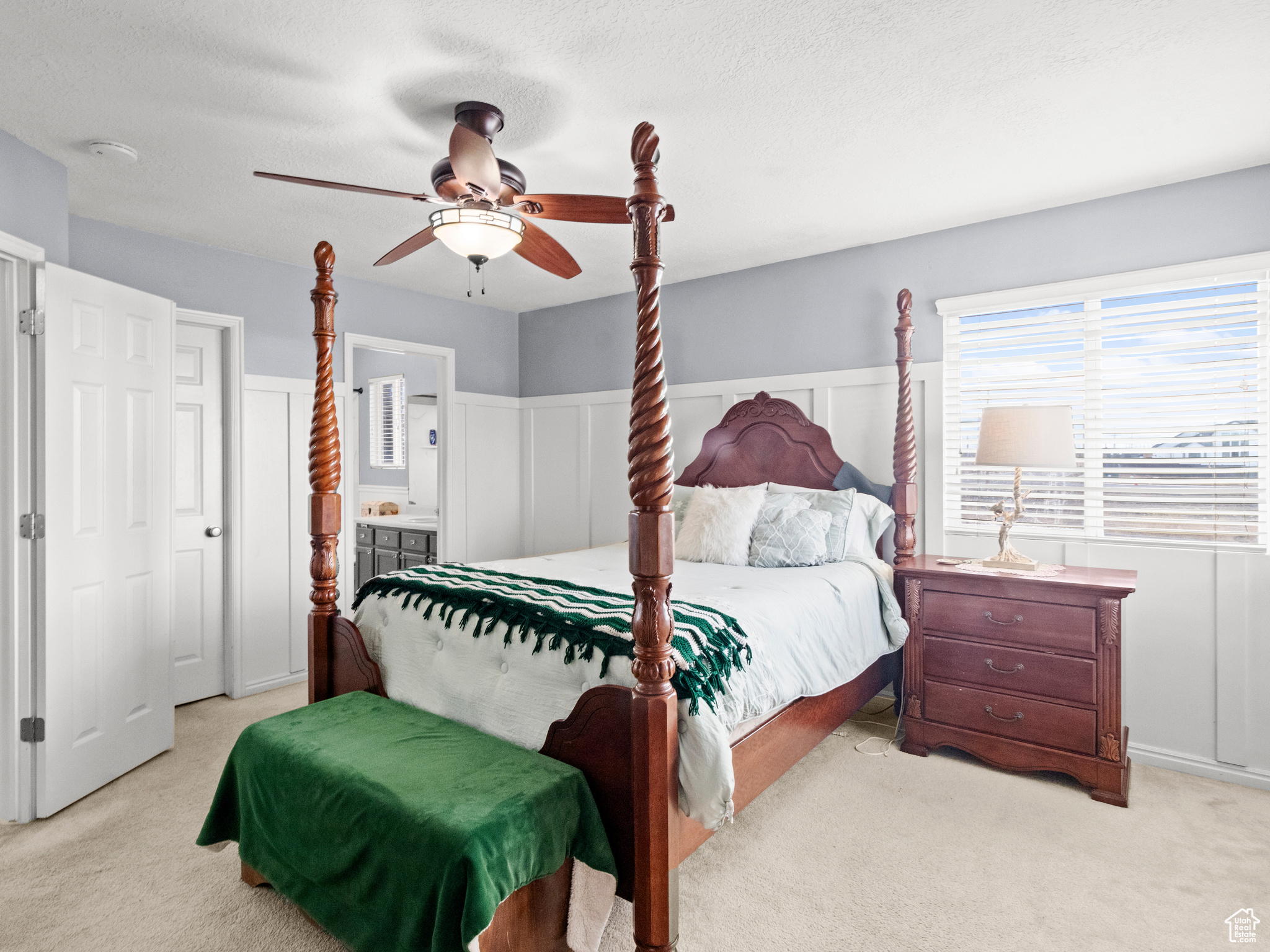 Carpeted bedroom with ceiling fan, a textured ceiling, and connected bathroom