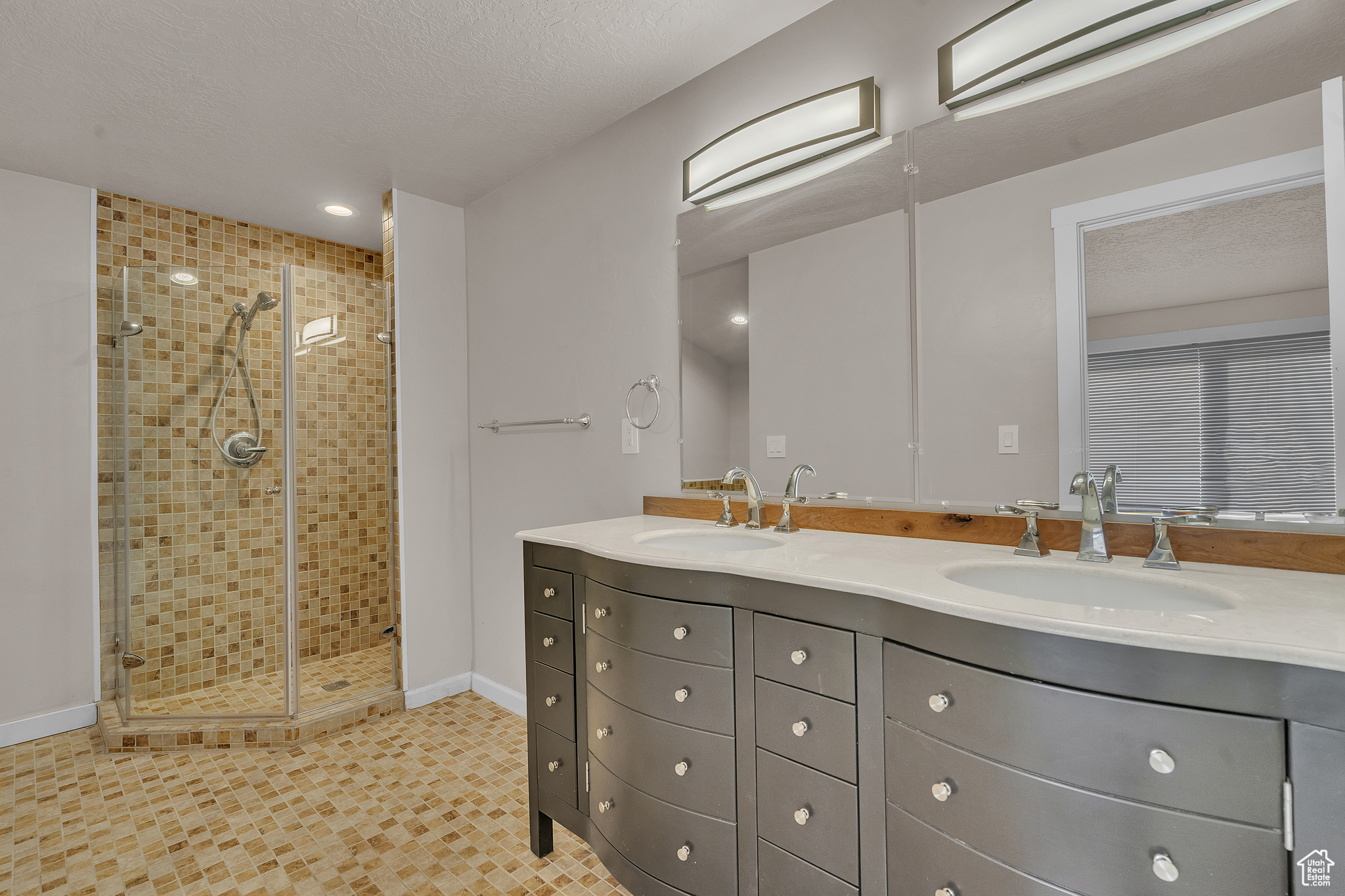 Bathroom featuring vanity, a textured ceiling, and walk in shower