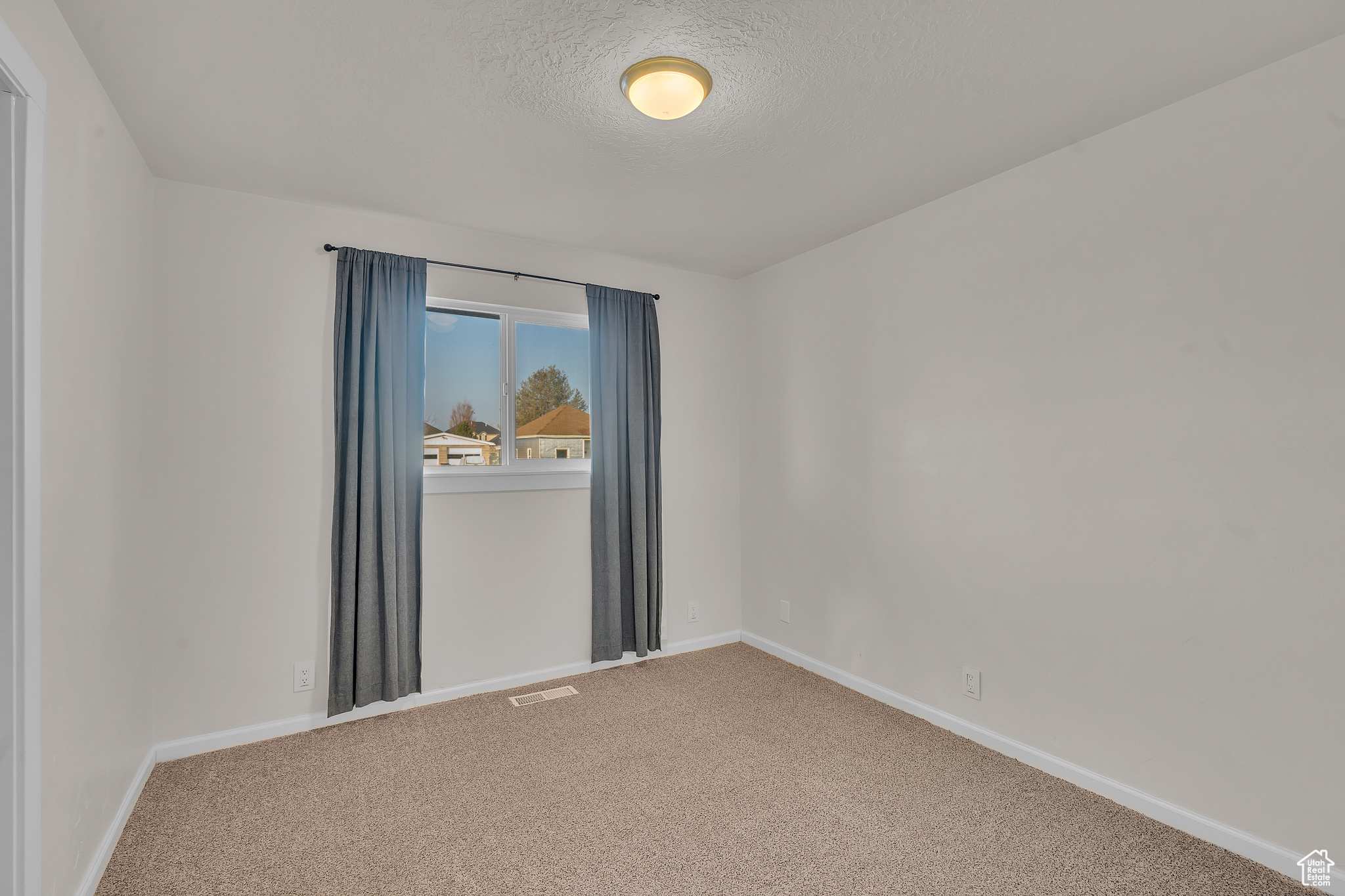 Spare room with carpet floors and a textured ceiling