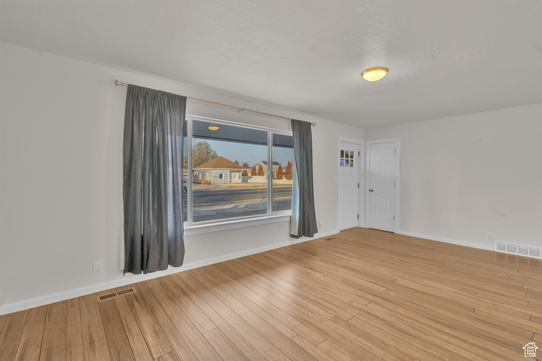 Spare room featuring a textured ceiling and light hardwood / wood-style floors