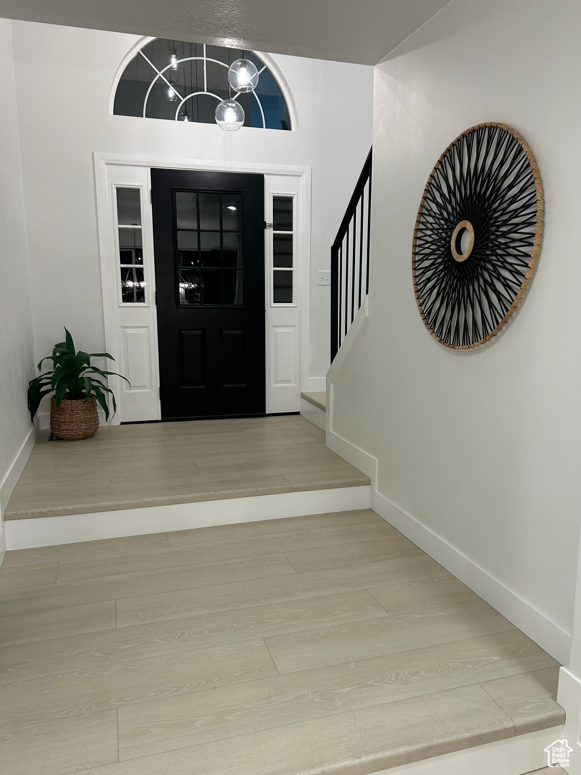 Entrance foyer featuring an inviting chandelier and light hardwood / wood-style flooring