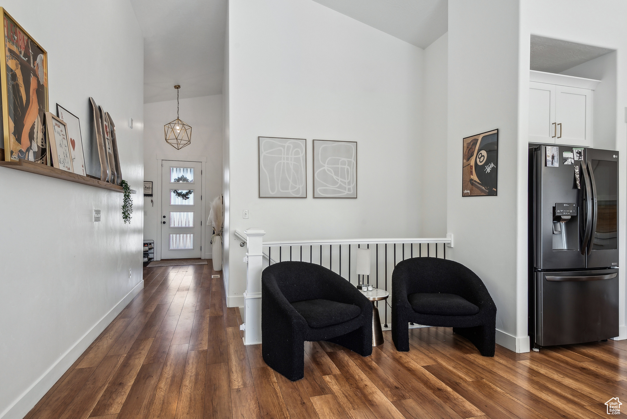 Foyer entrance with dark hardwood / wood-style flooring and a towering ceiling