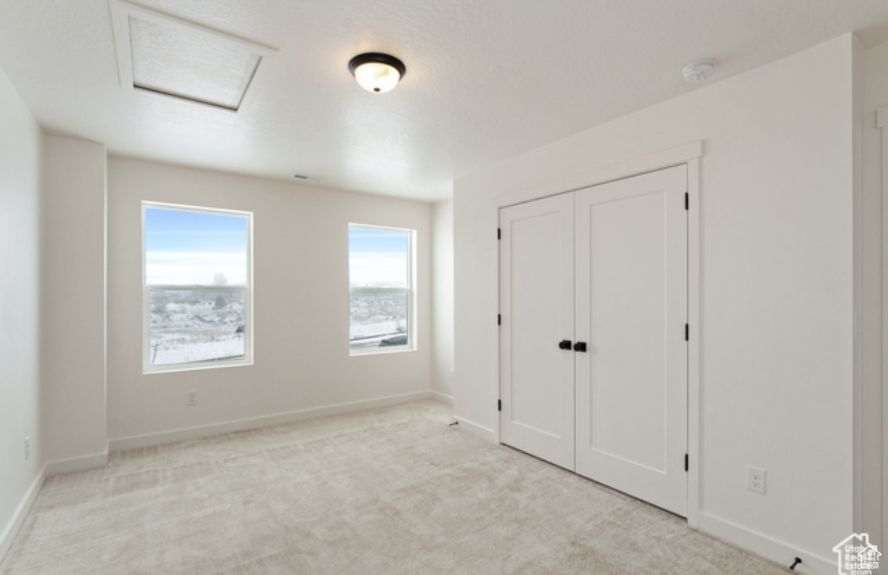 Unfurnished bedroom featuring light carpet