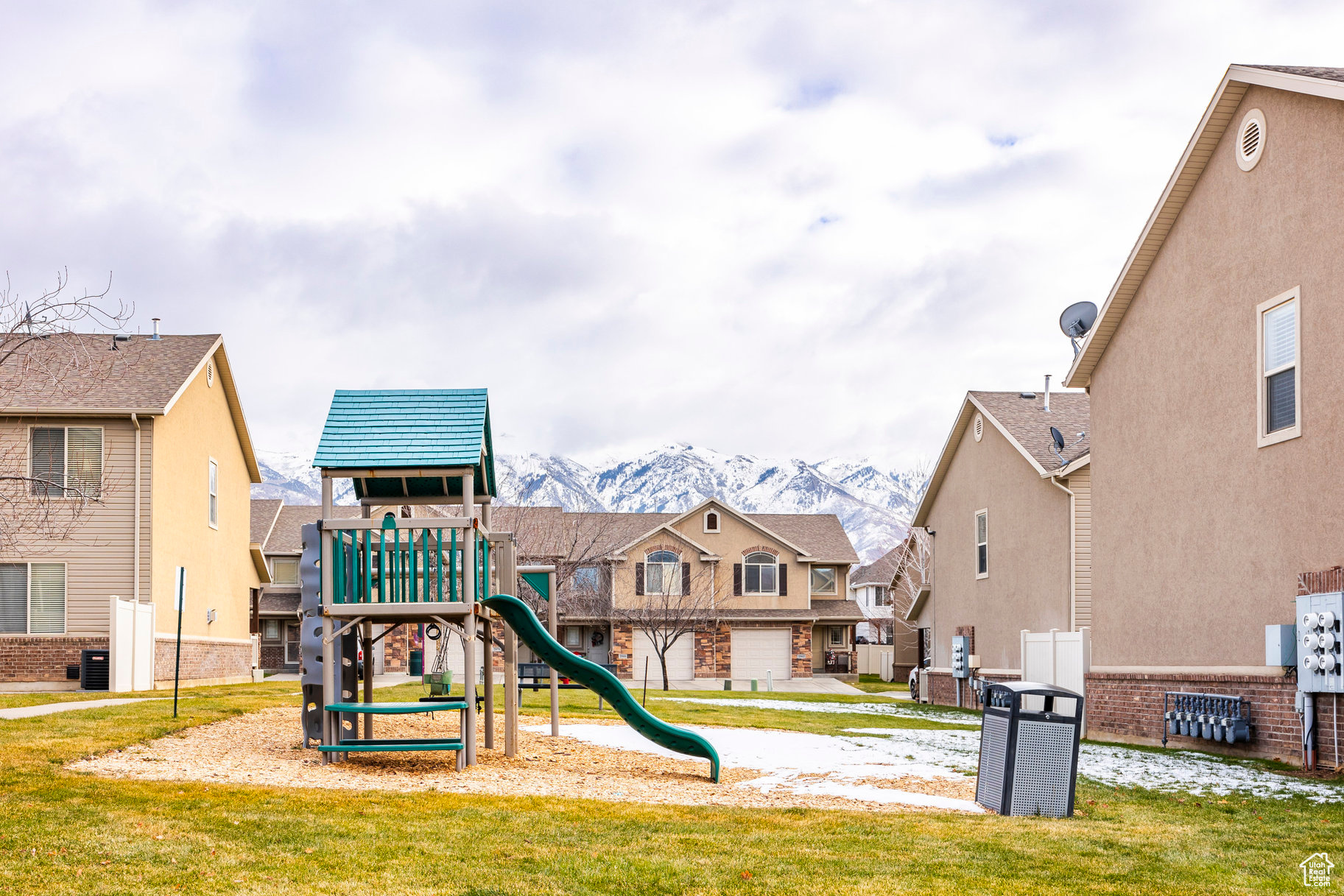 View of playground with a mountain view, central air condition unit, and a lawn