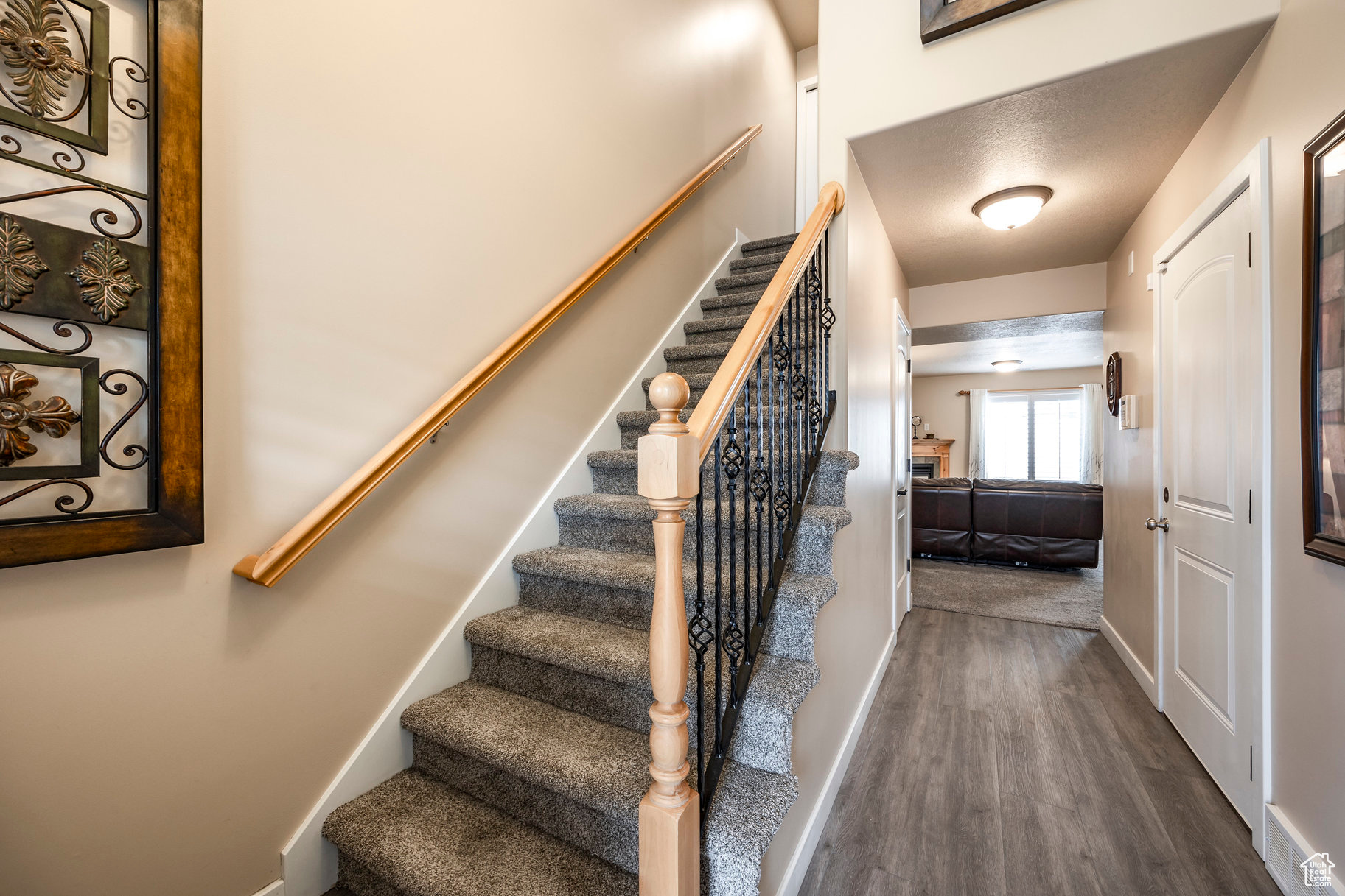 Stairs featuring a textured ceiling and hardwood / wood-style flooring