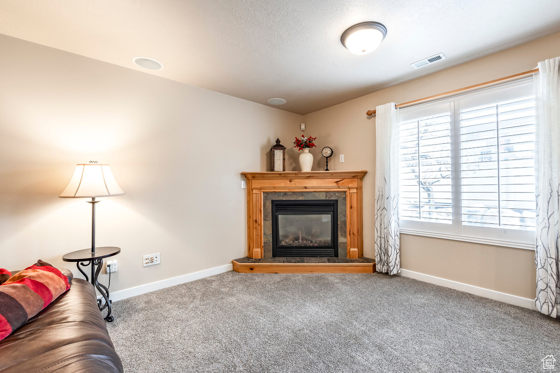 Living room featuring carpet flooring and a tile fireplace