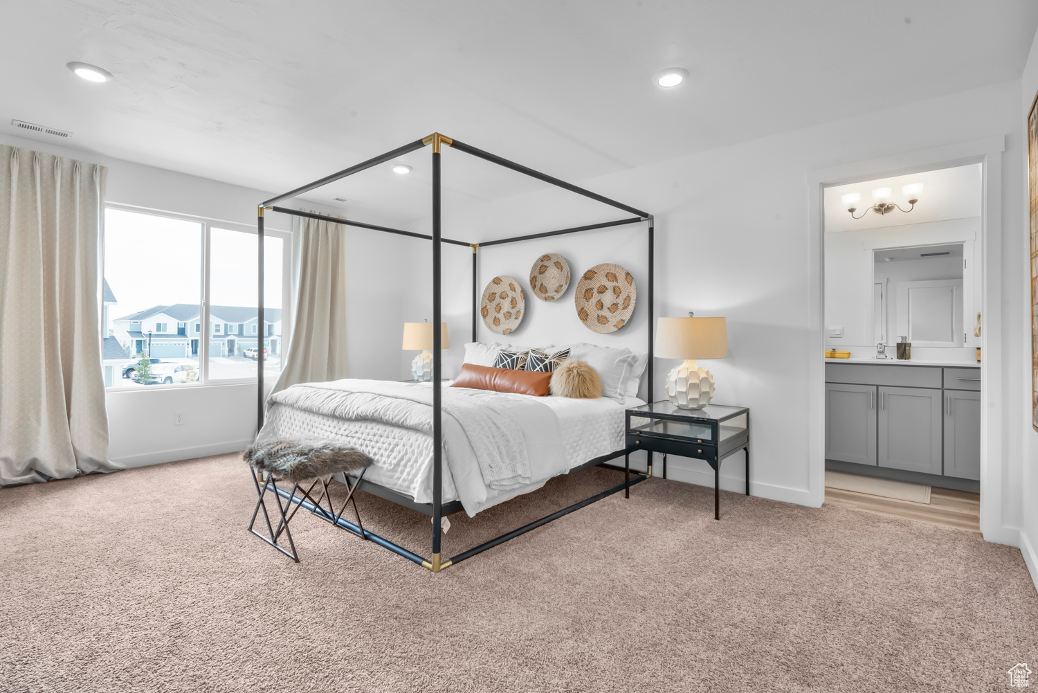 Carpeted bedroom featuring sink and connected bathroom