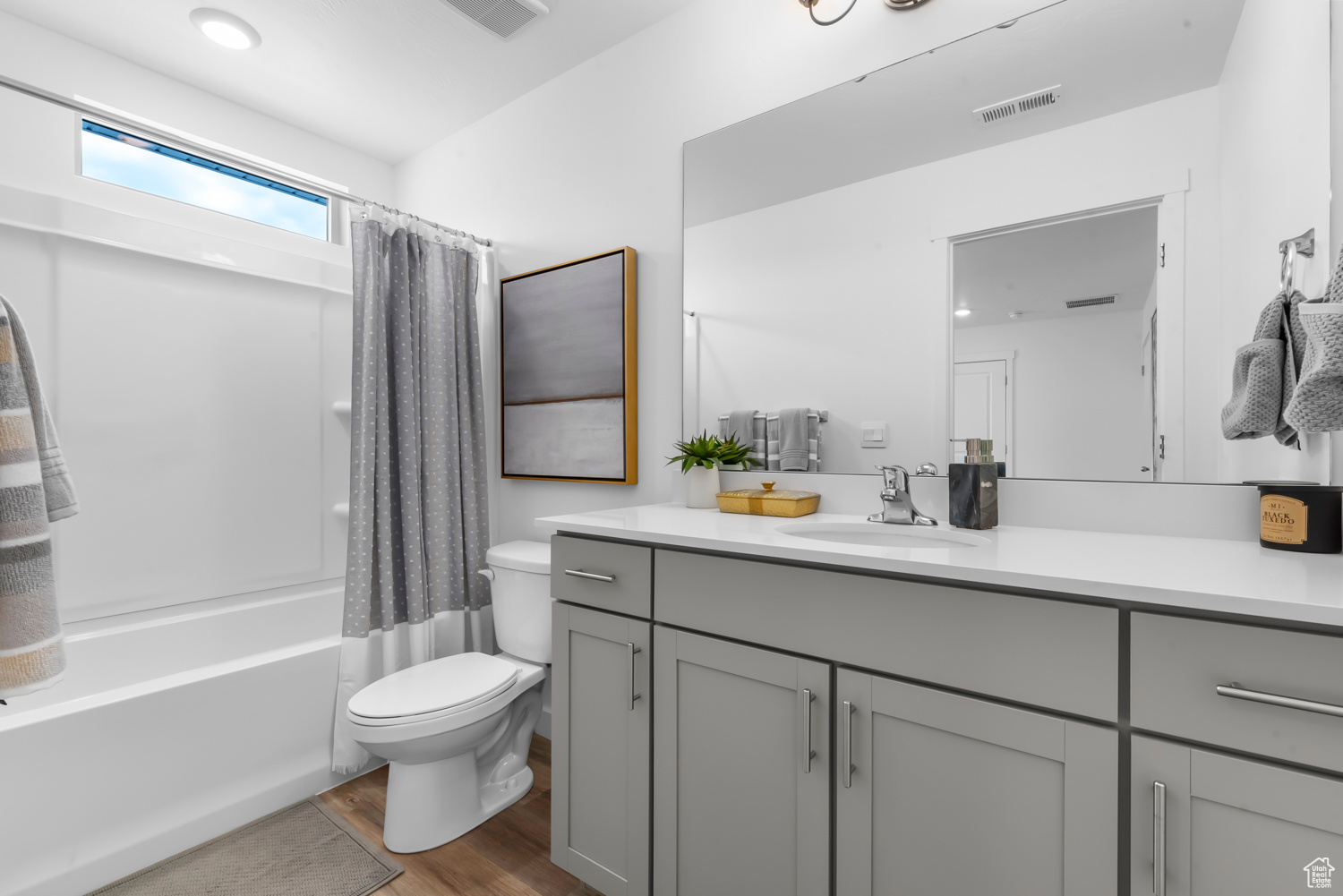 Full bathroom featuring vanity, toilet, wood-type flooring, and shower / tub combo with curtain