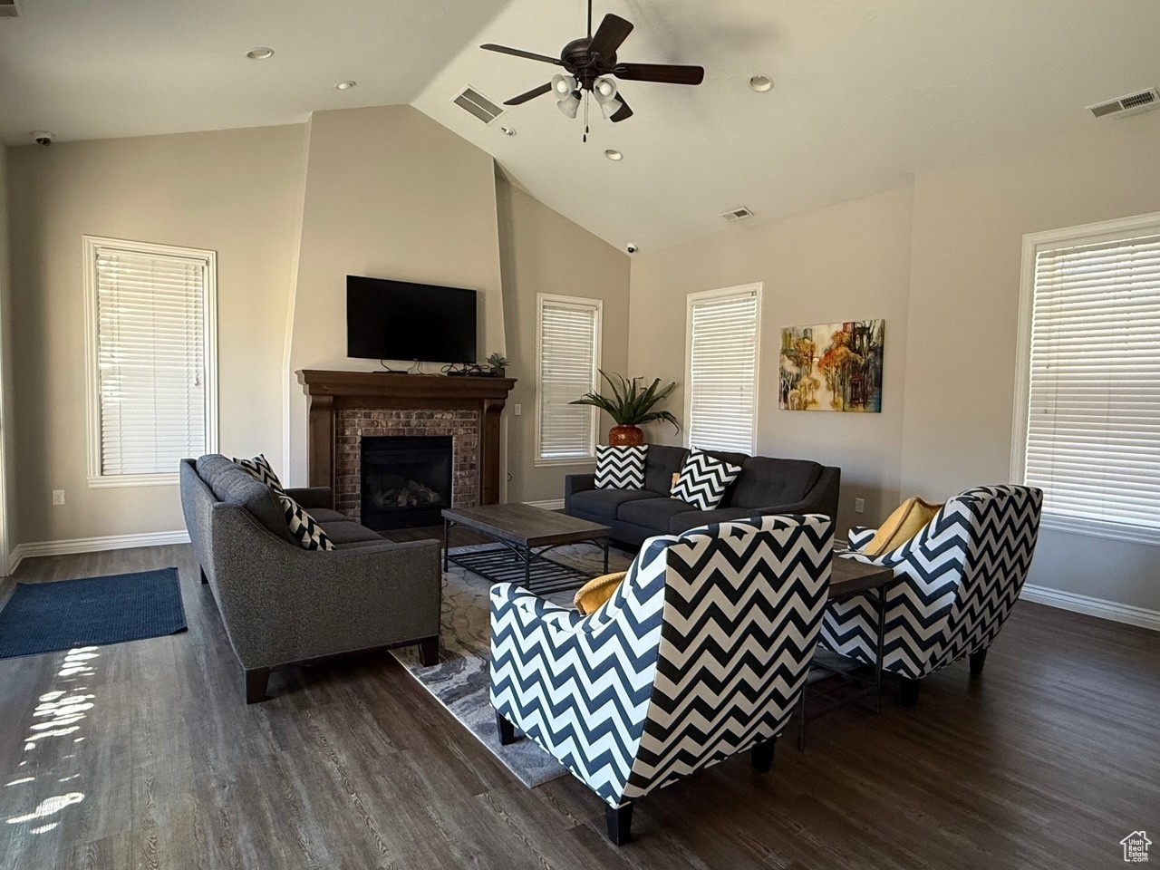 Living room featuring lofted ceiling, dark wood-type flooring, and a wealth of natural light