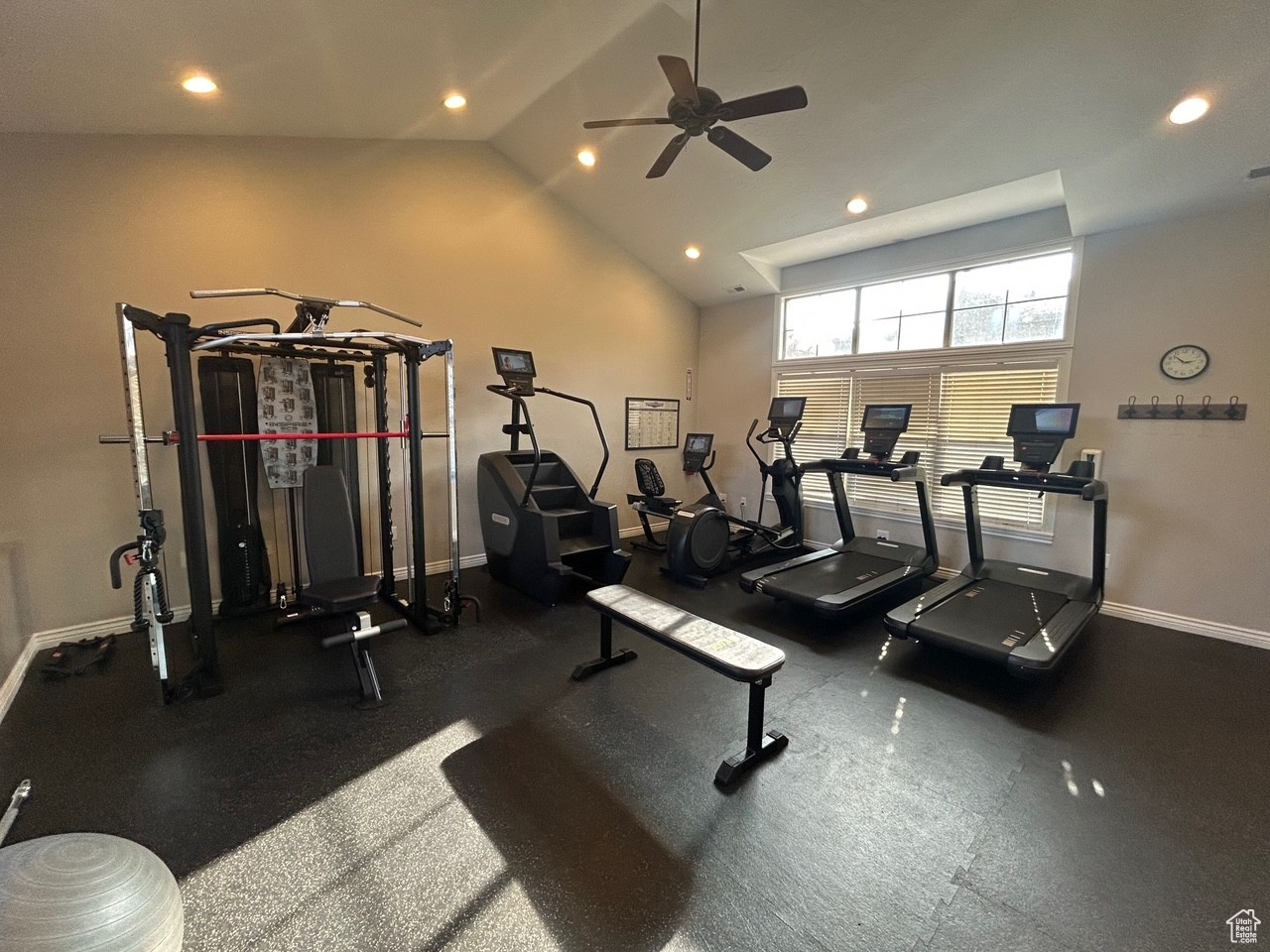 Workout area with ceiling fan and high vaulted ceiling