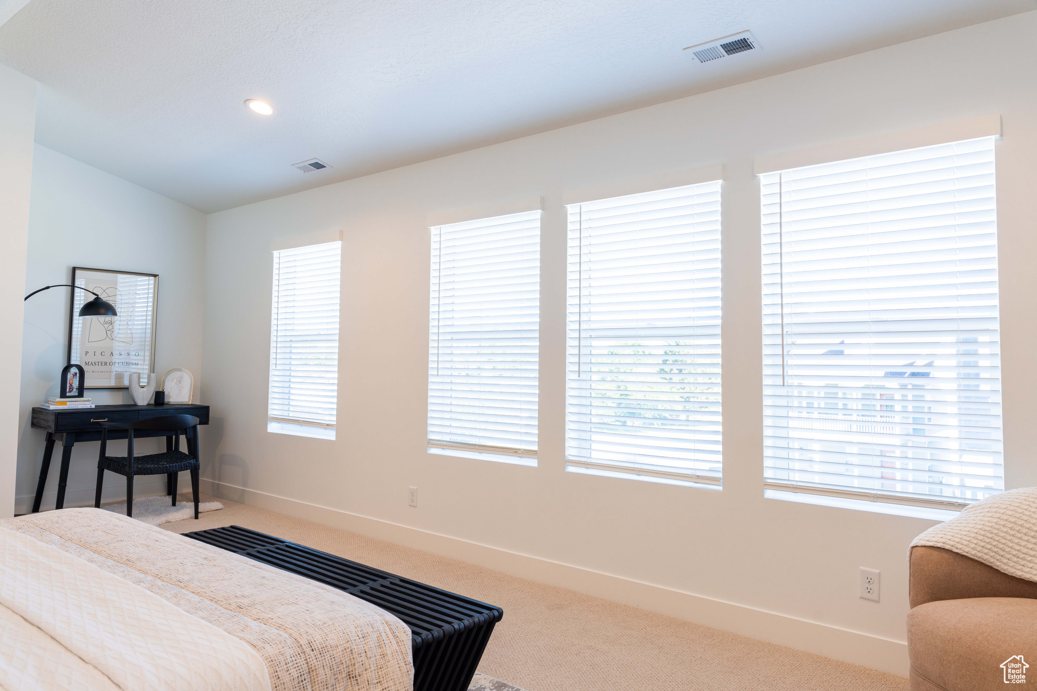 Carpeted bedroom with lofted ceiling and multiple windows