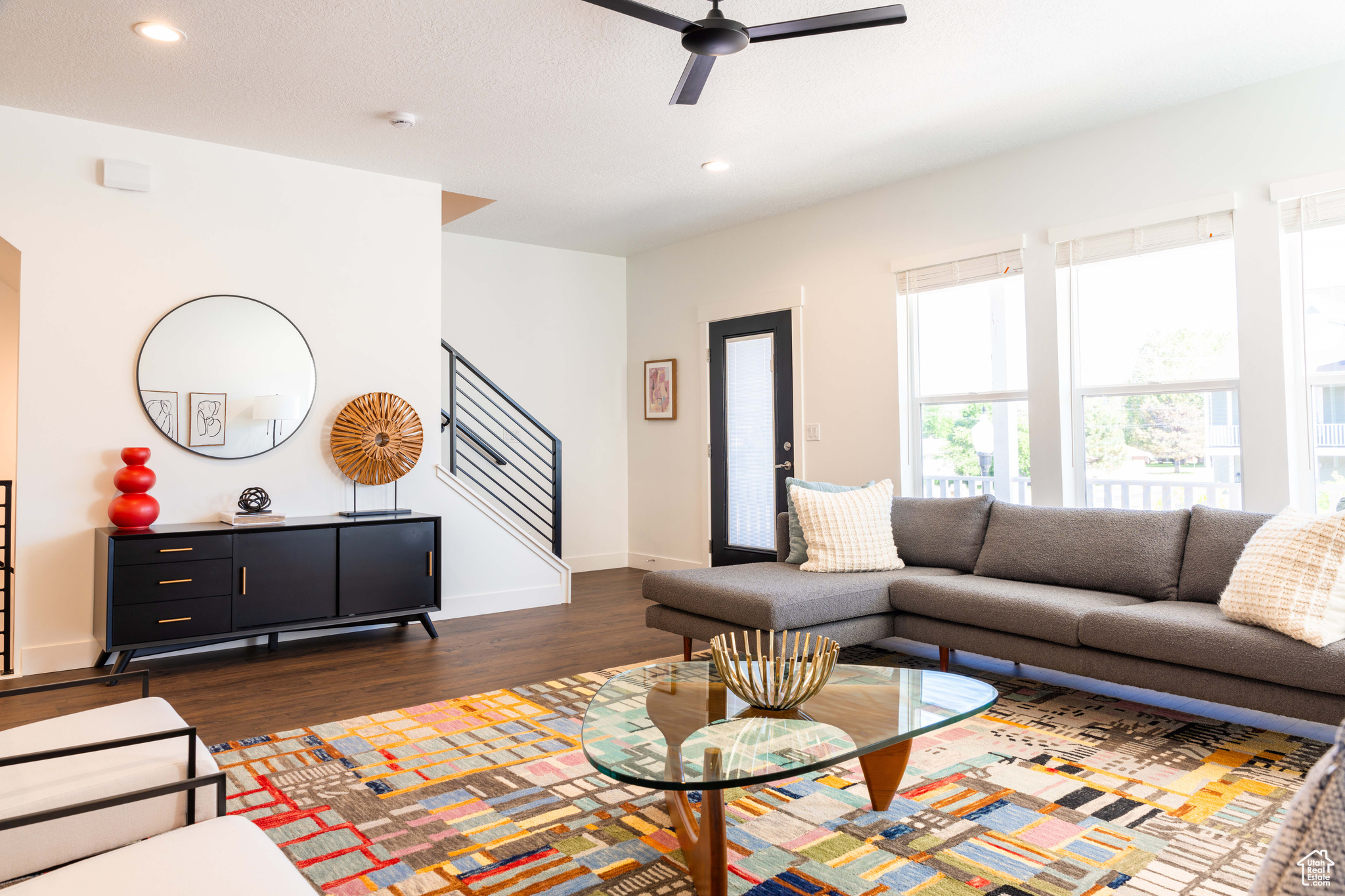 Living room with ceiling fan and dark hardwood / wood-style floors