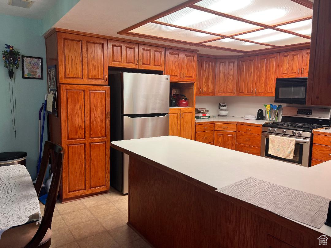 Kitchen featuring kitchen peninsula and appliances with stainless steel finishes