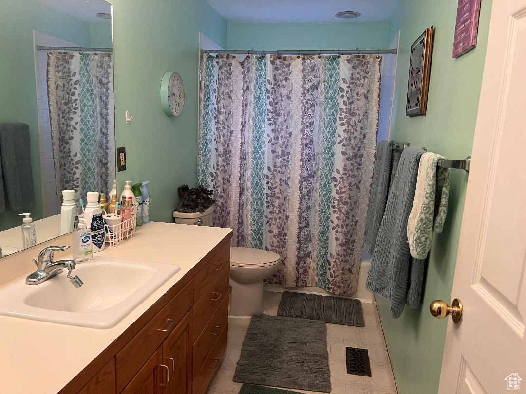 Full bathroom with vanity, toilet, and shower / bathtub combination with curtain