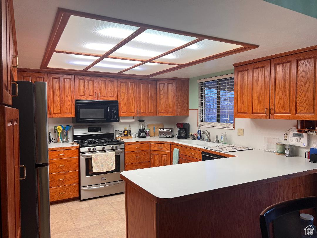 Kitchen with sink, kitchen peninsula, and stainless steel appliances