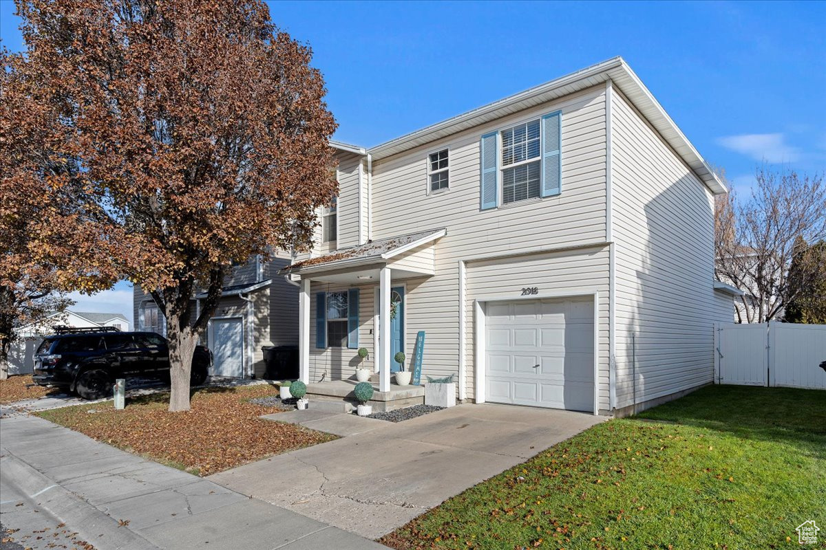 View of front property featuring a garage and a front lawn