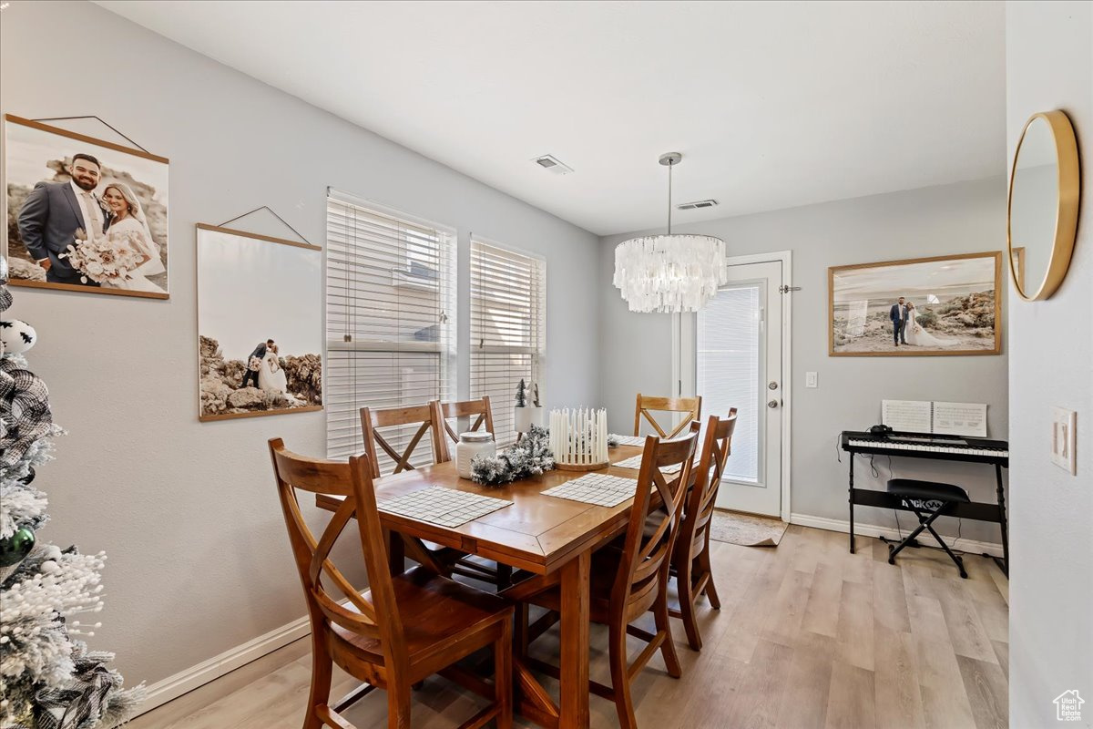 Dining room featuring an inviting chandelier and light hardwood / wood-style flooring