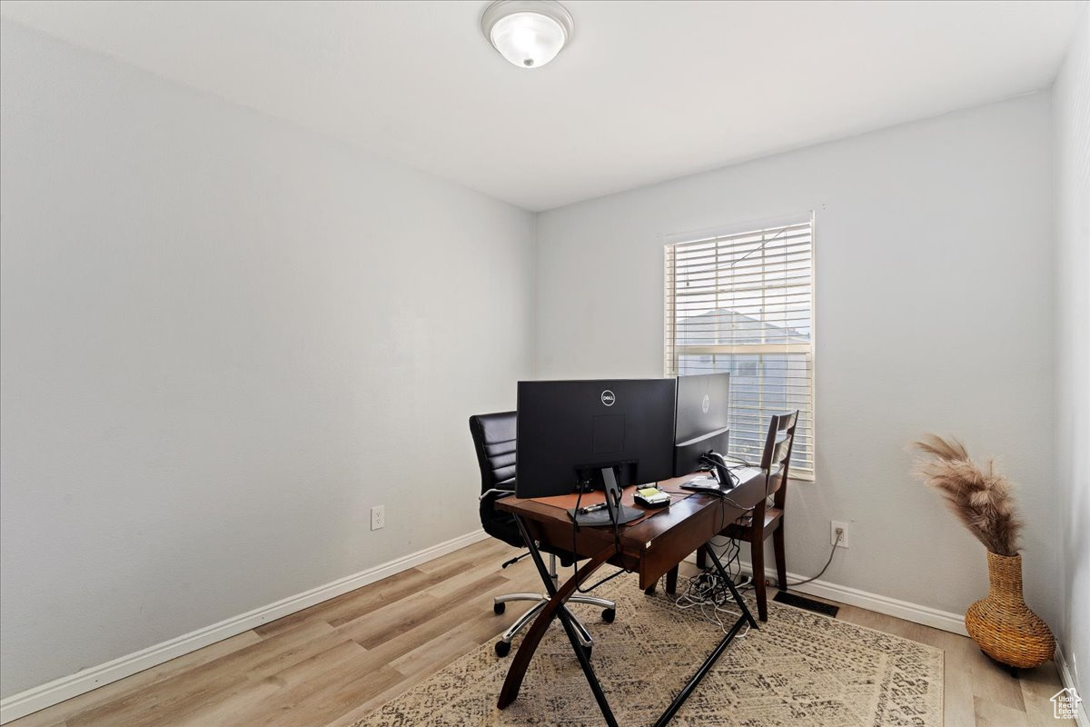 Office area with light hardwood / wood-style floors