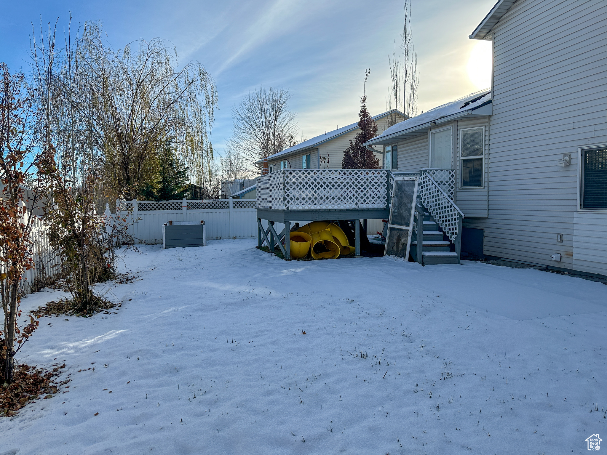 Yard covered in snow with a deck