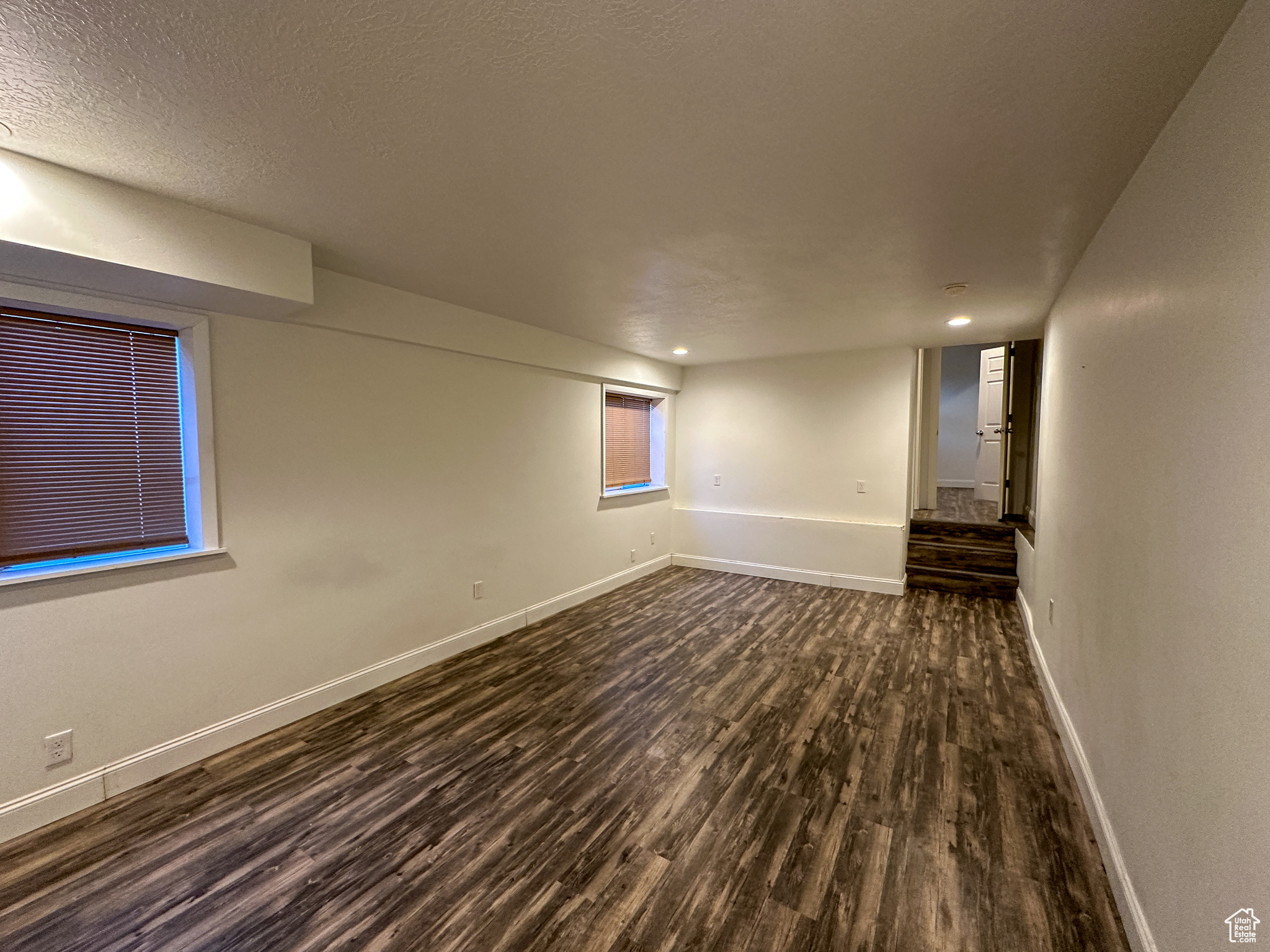 Spare room featuring a textured ceiling and dark hardwood / wood-style floors