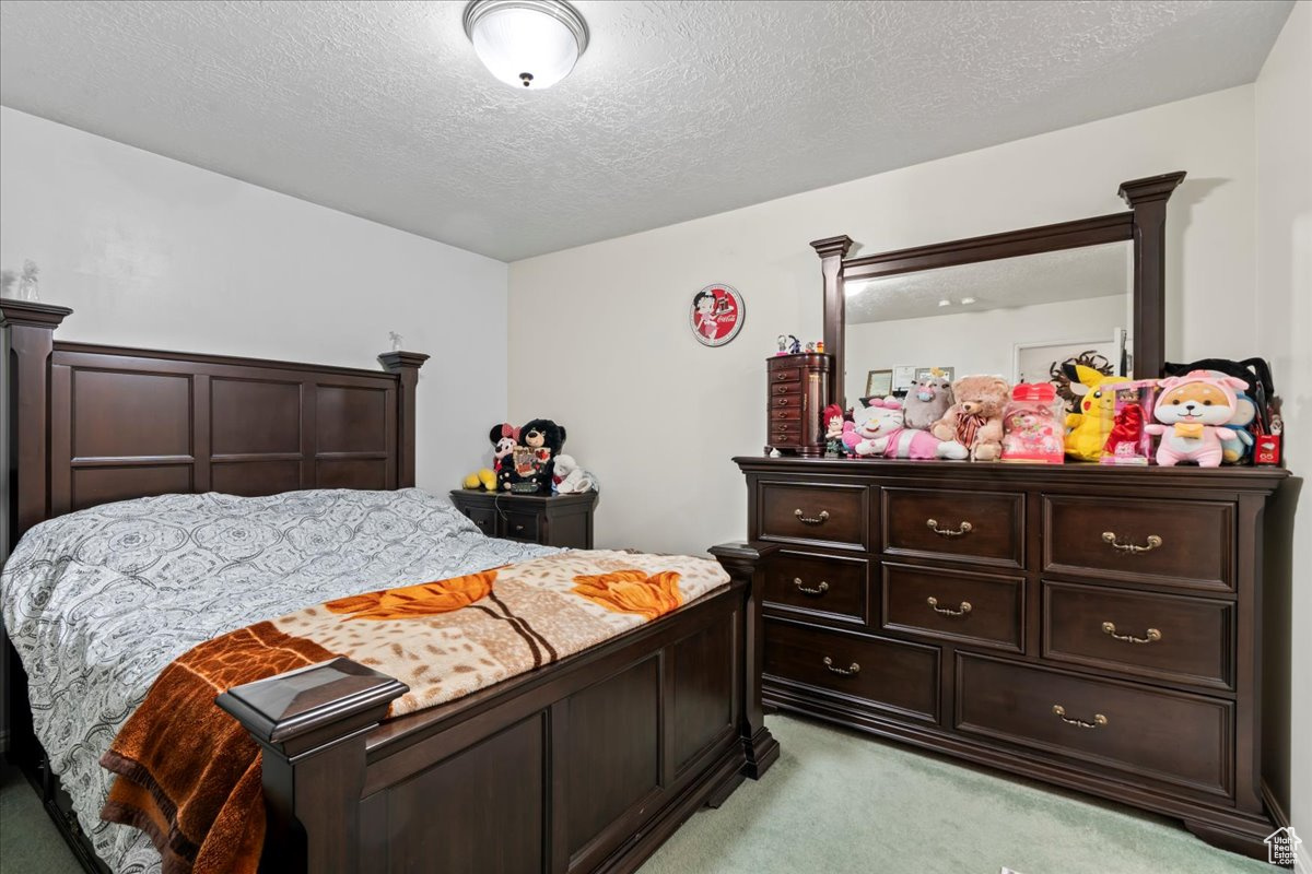 Carpeted bedroom featuring a textured ceiling