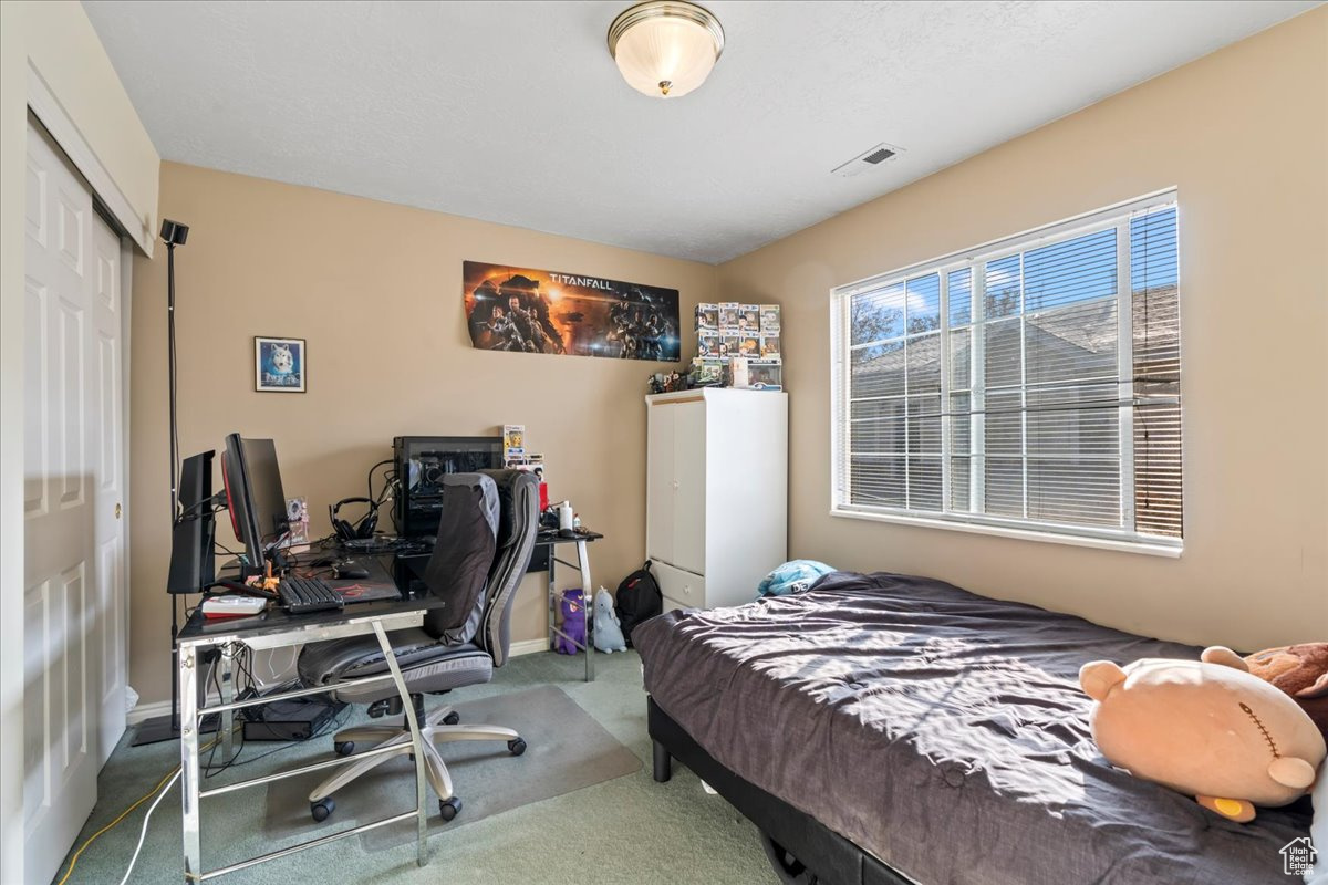 Carpeted bedroom with a closet