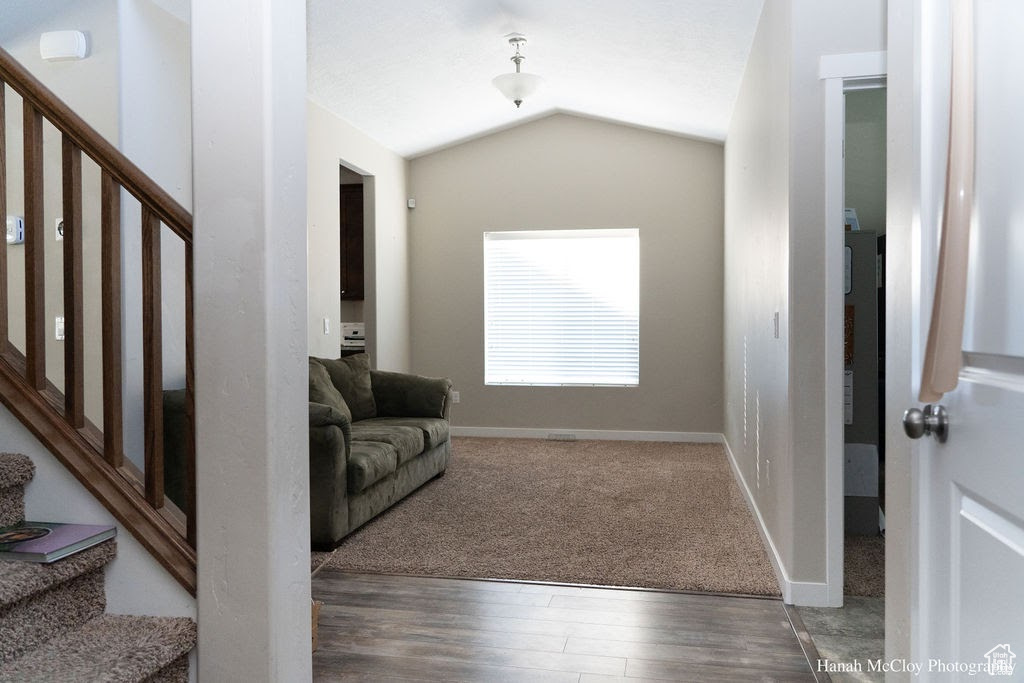 Interior space with dark hardwood / wood-style floors and lofted ceiling