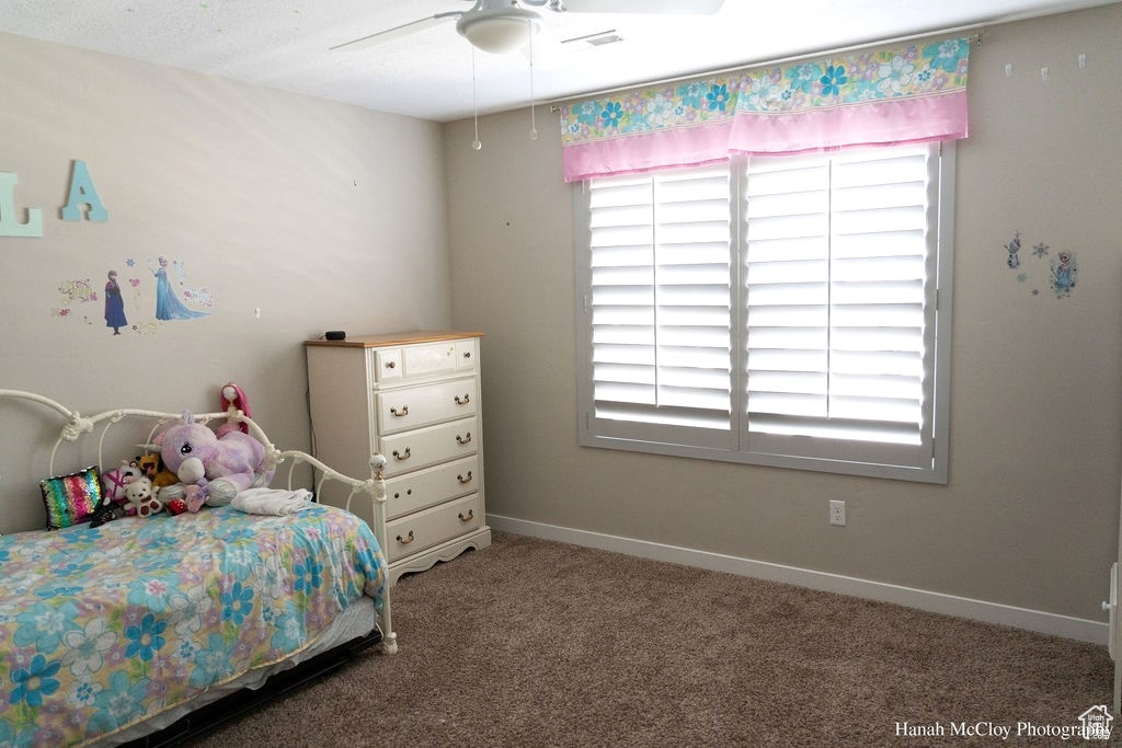 Carpeted bedroom with ceiling fan