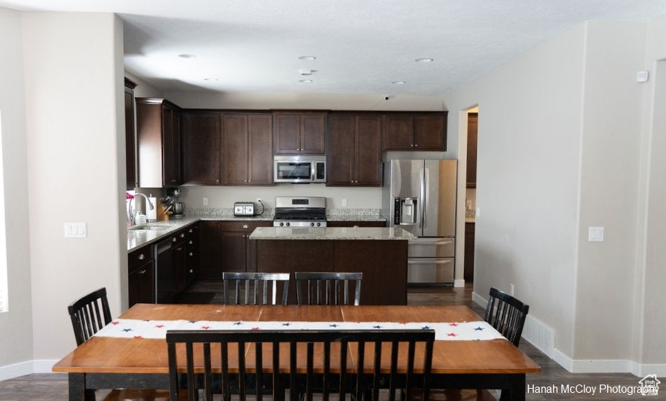 Kitchen featuring sink, dark hardwood / wood-style flooring, a kitchen island, and appliances with stainless steel finishes