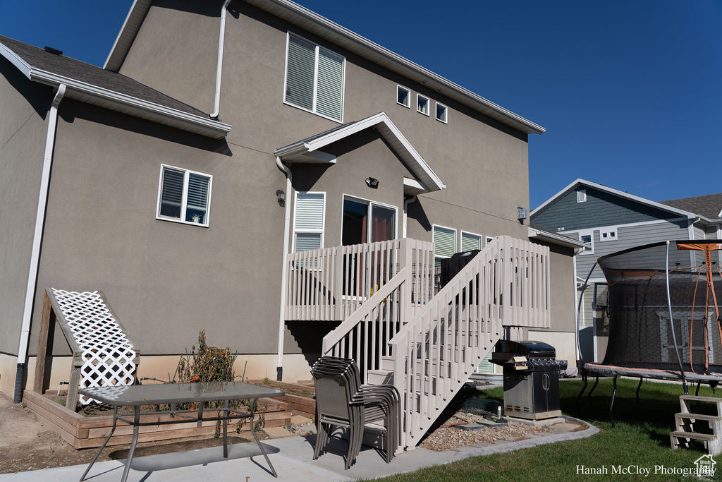 Back of property featuring a patio and a trampoline