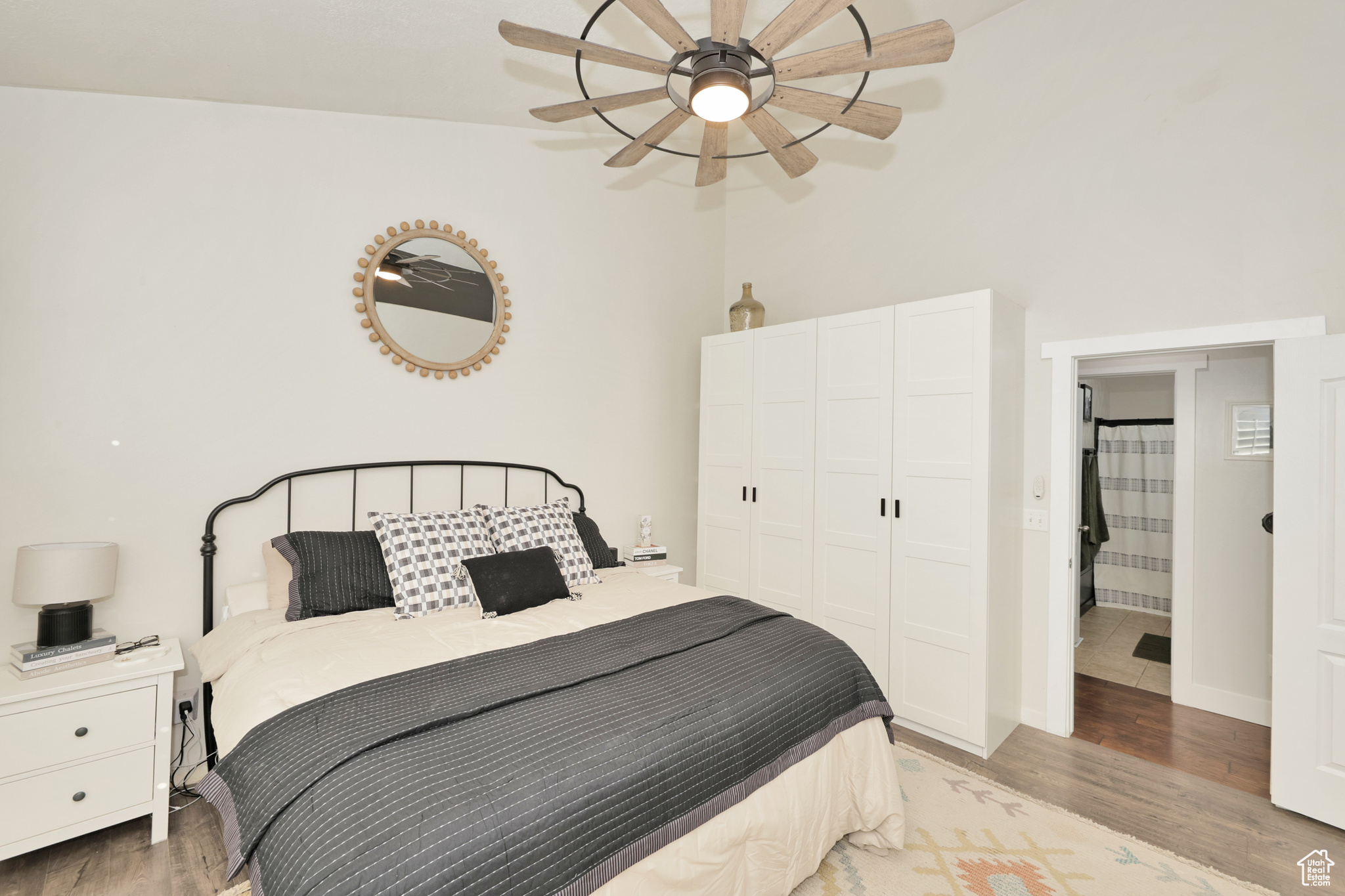 Bedroom with a closet, ceiling fan, light hardwood / wood-style flooring, and vaulted ceiling