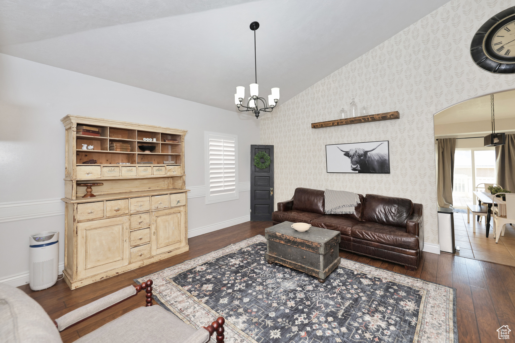 Living room featuring a chandelier, dark hardwood / wood-style flooring, and vaulted ceiling