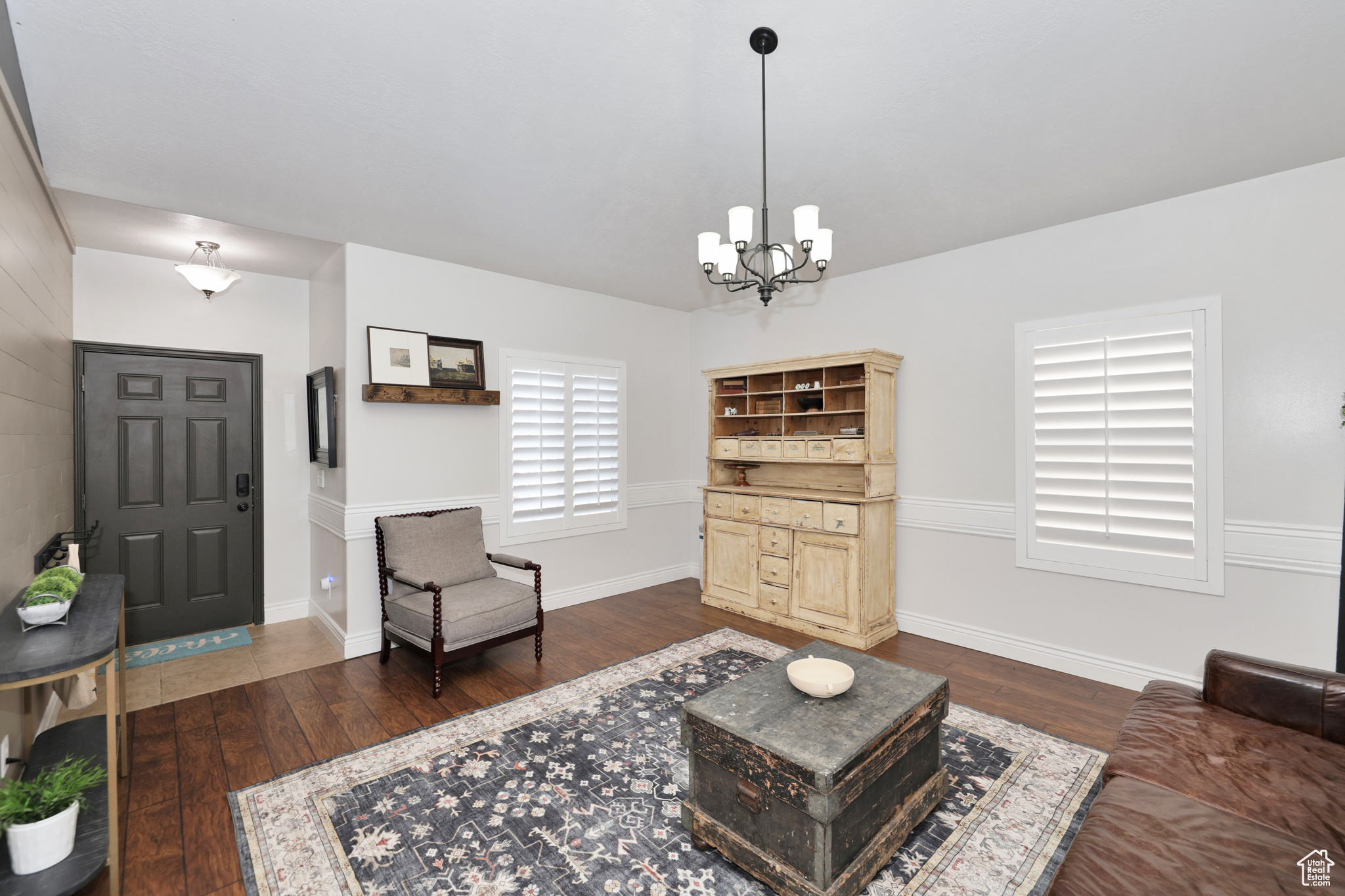 Living room with a chandelier and dark hardwood / wood-style floors