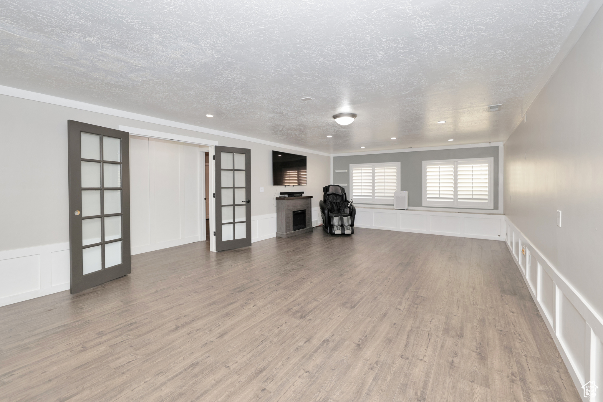 Unfurnished living room with hardwood / wood-style floors and a textured ceiling