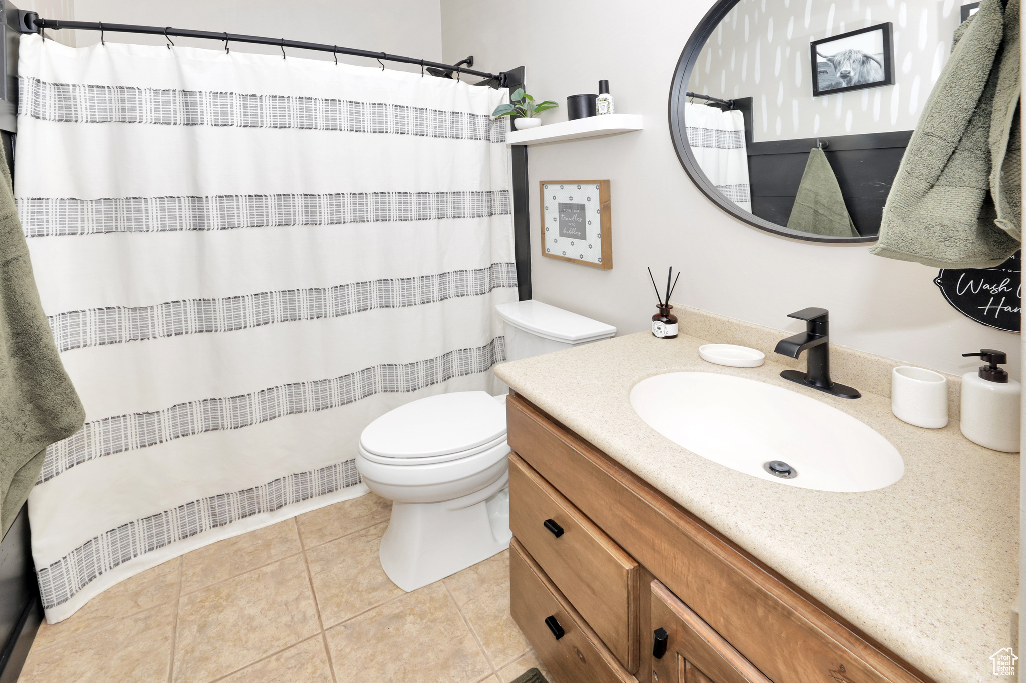 Bathroom featuring toilet, vanity, and tile patterned floors