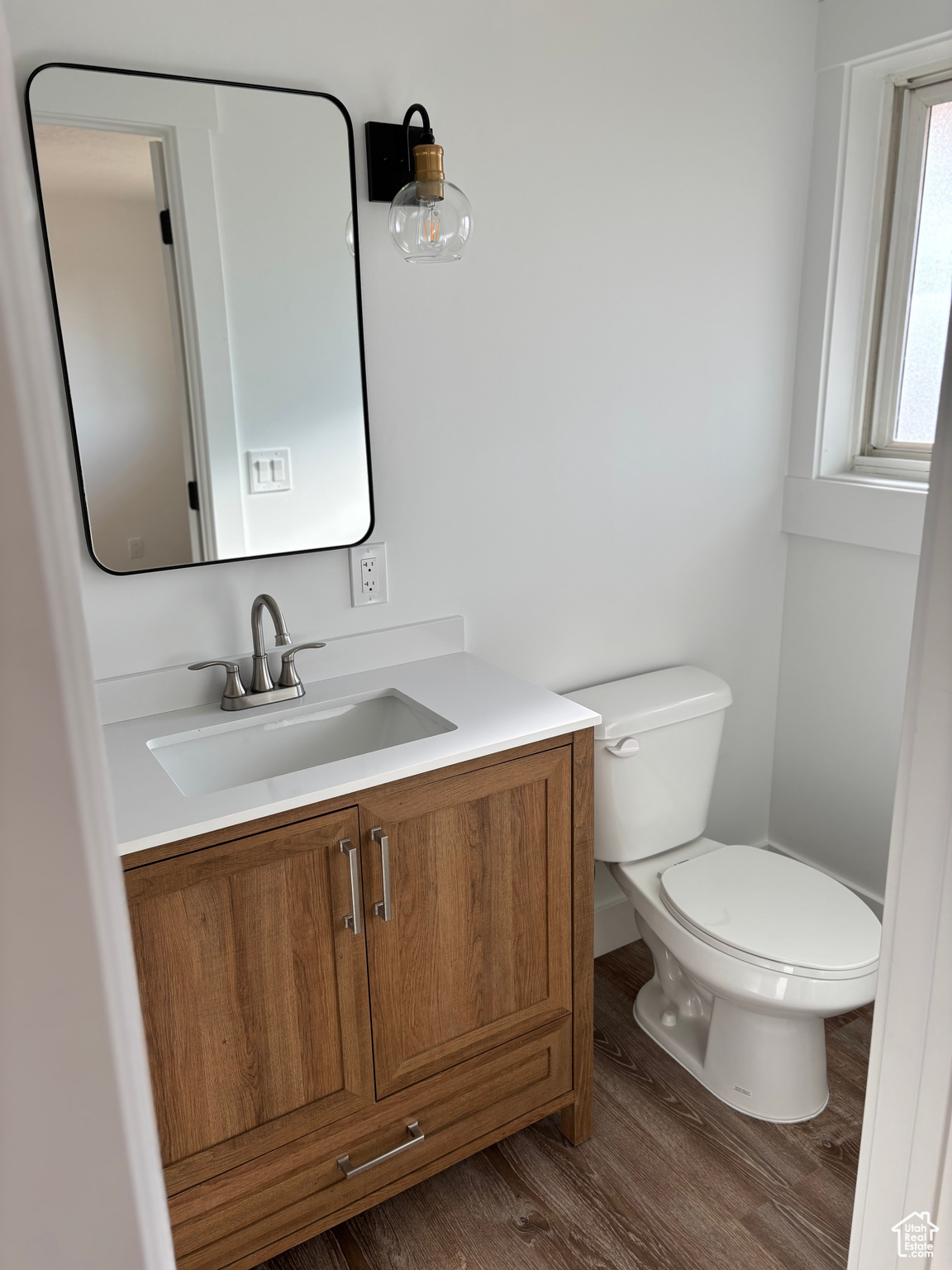 Bathroom with vanity, hardwood / wood-style flooring, and toilet