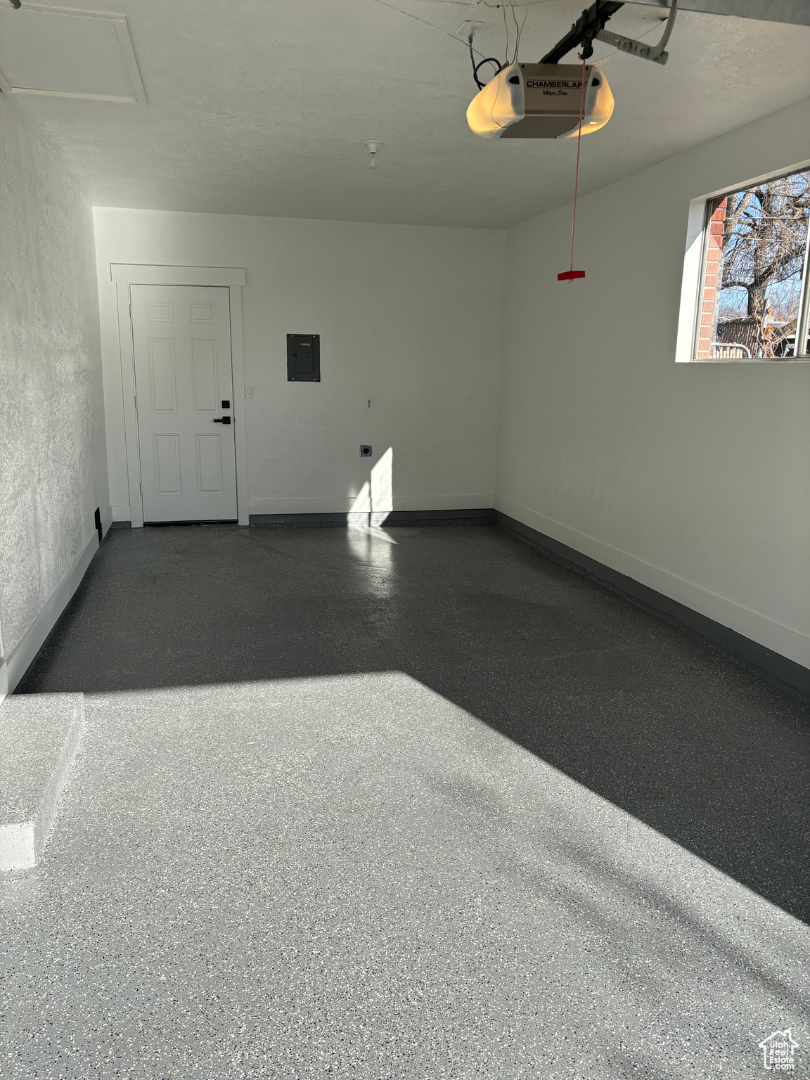 Garage featuring electric panel and a garage door opener