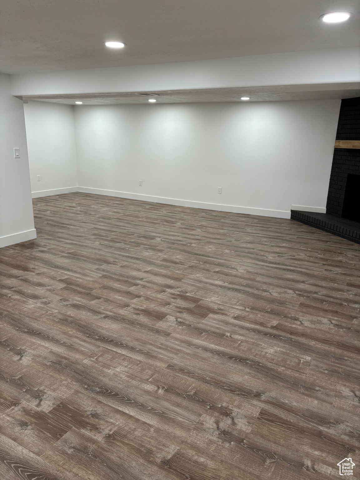 Basement with a fireplace and dark hardwood / wood-style flooring