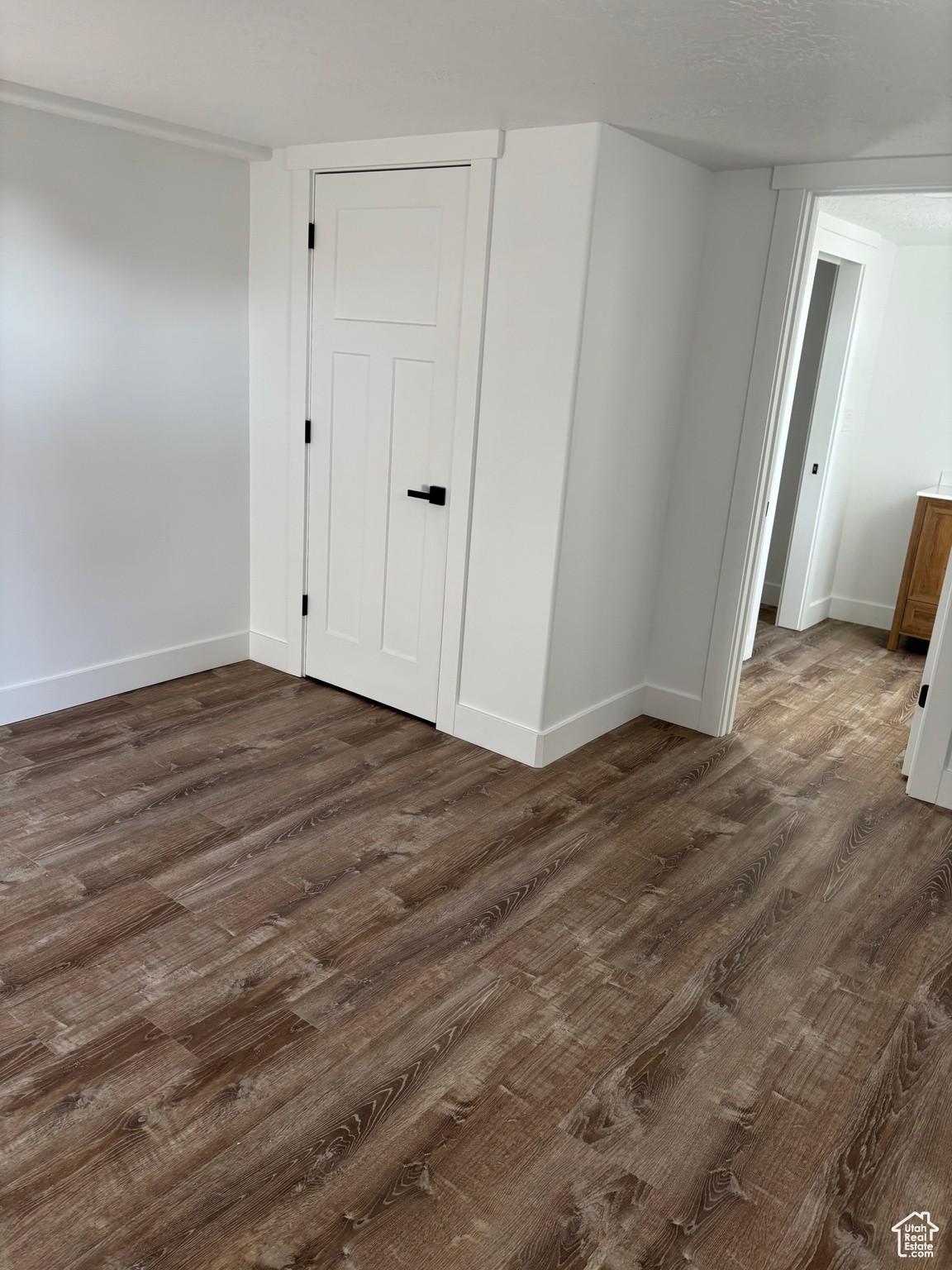 Unfurnished room with dark wood-type flooring