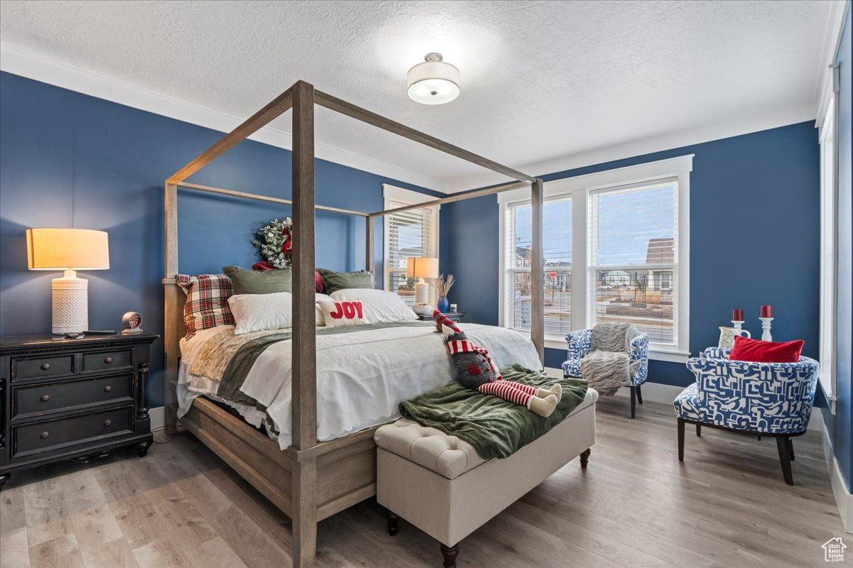 Bedroom with hardwood / wood-style floors and a textured ceiling