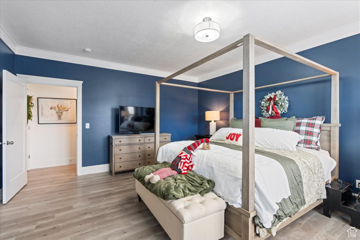 Bedroom featuring wood-type flooring and ornamental molding