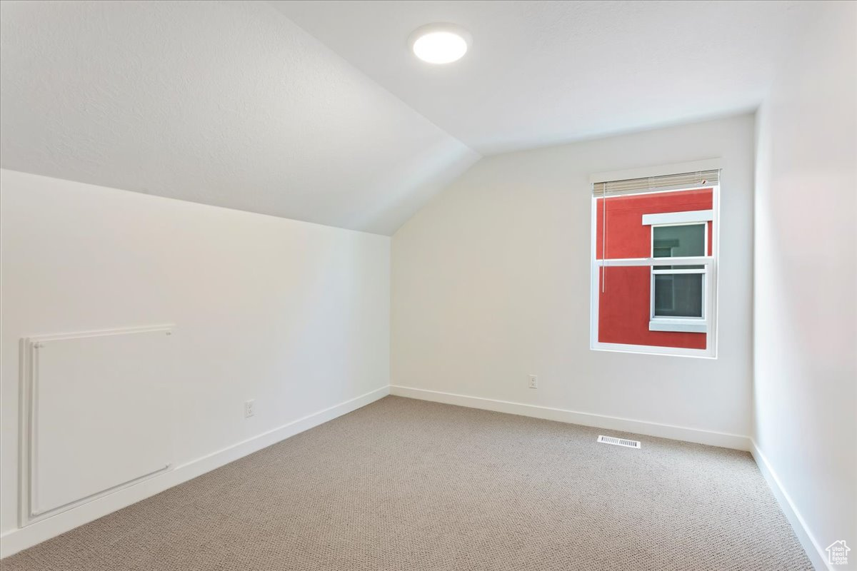 Bonus room with carpet floors and vaulted ceiling